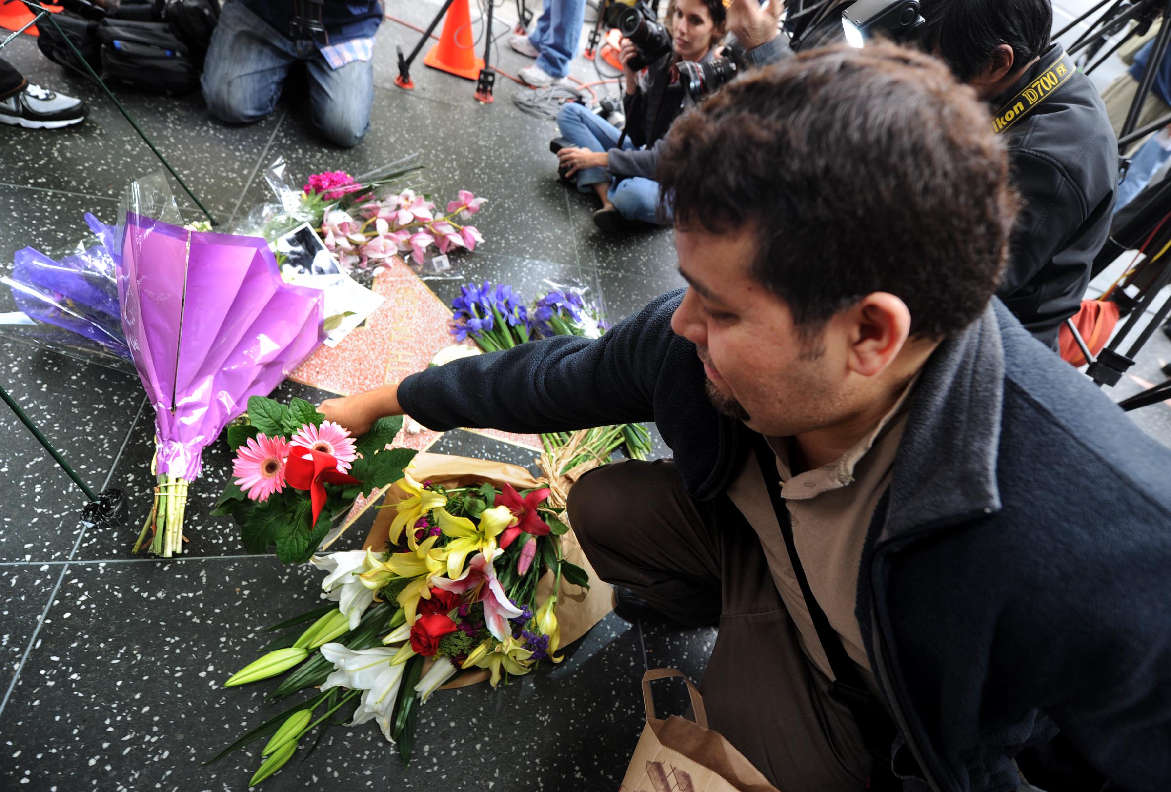 A fan places flowers on the actress's star at the Hollywood Walk of Fame in Hollywood, California on March 23, 2011 | Source: Getty Images