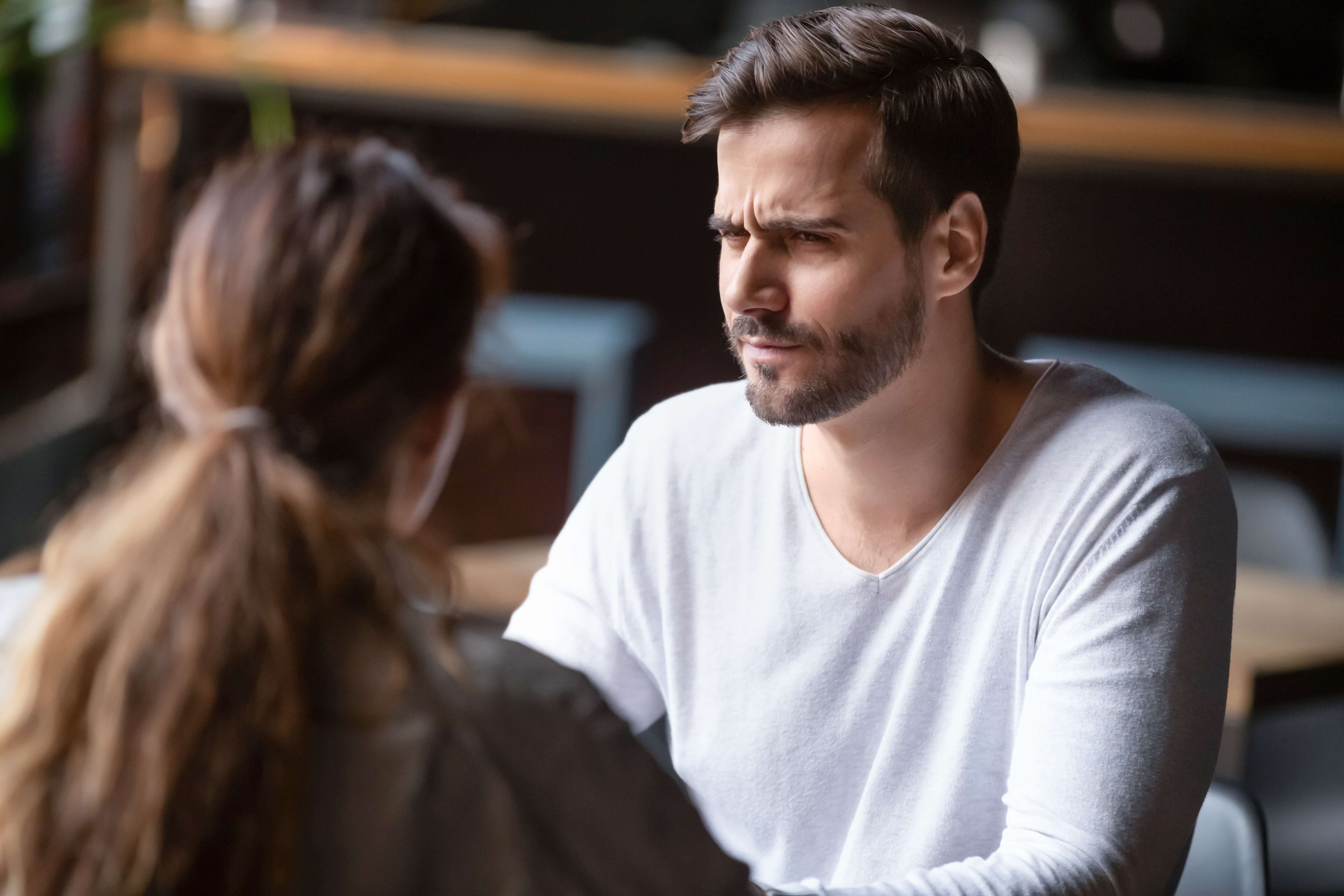 A man with a doubtful look while talking to a woman | Source: Shutterstock