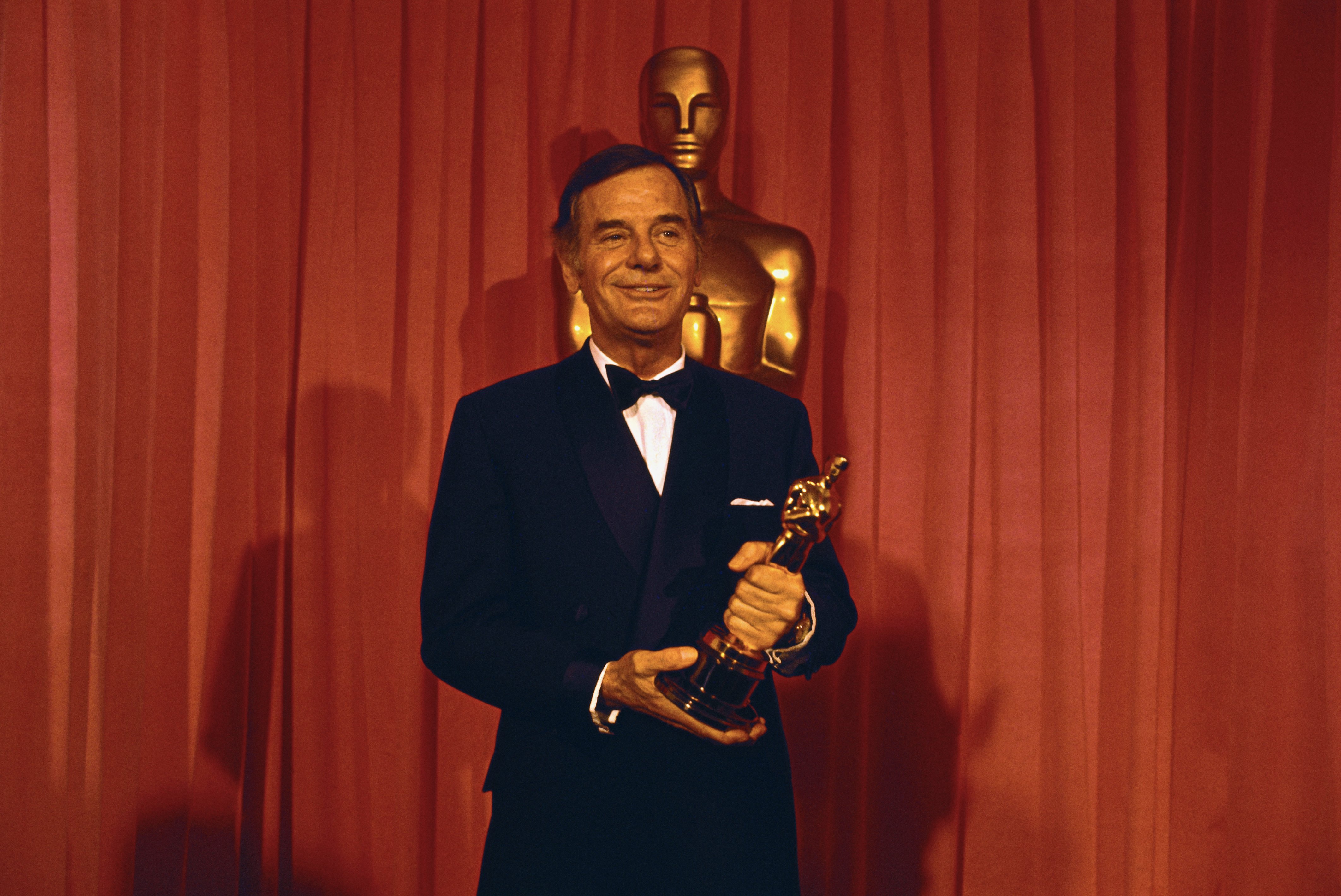 Gig Young holds the Oscar he won for Best Supporting Actor, for "They Shoot Horses, Don't They?" at the Academy Award, 1969. | Photo: Getty Images