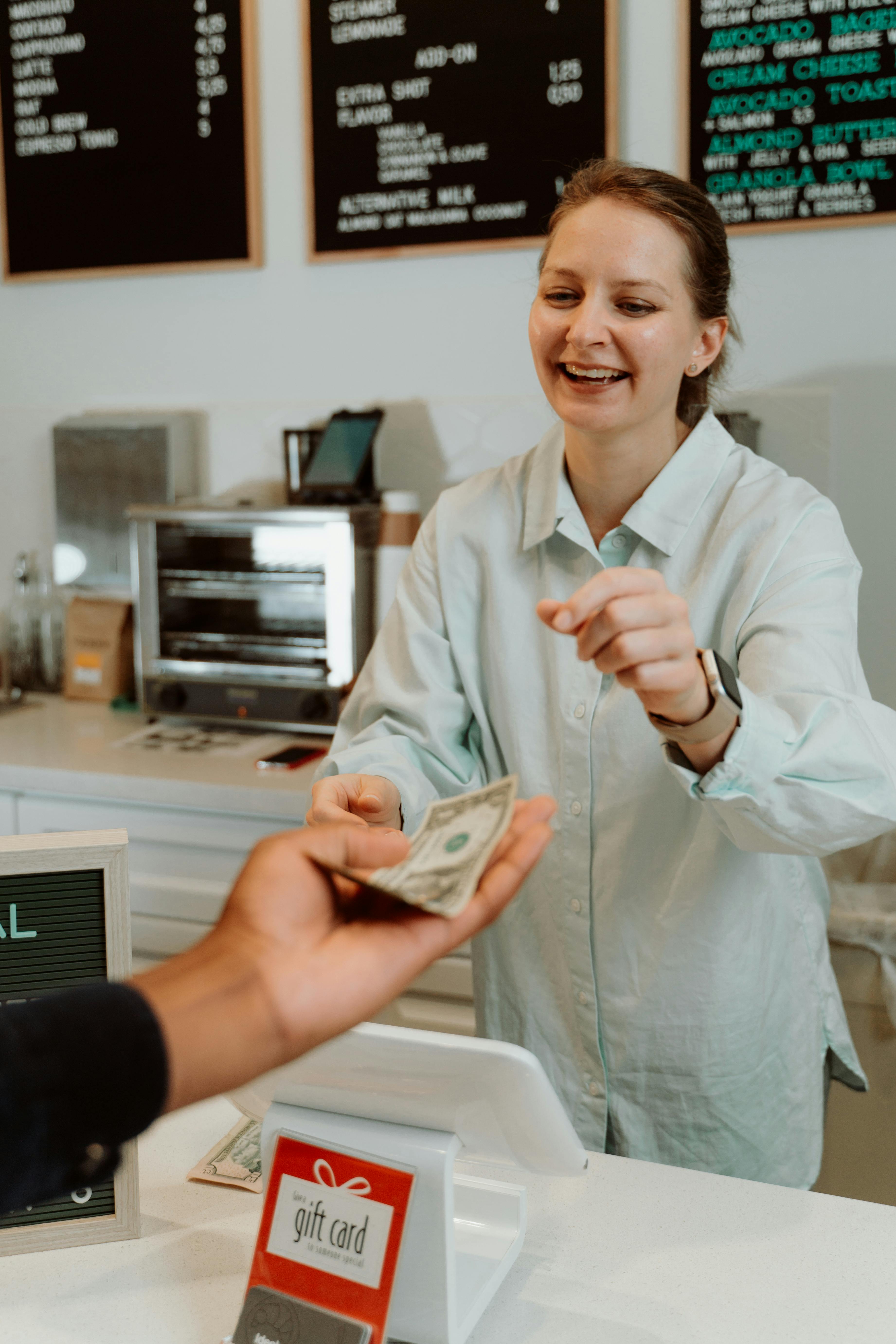 A woman receiving money from a customer | Source: Pexels
