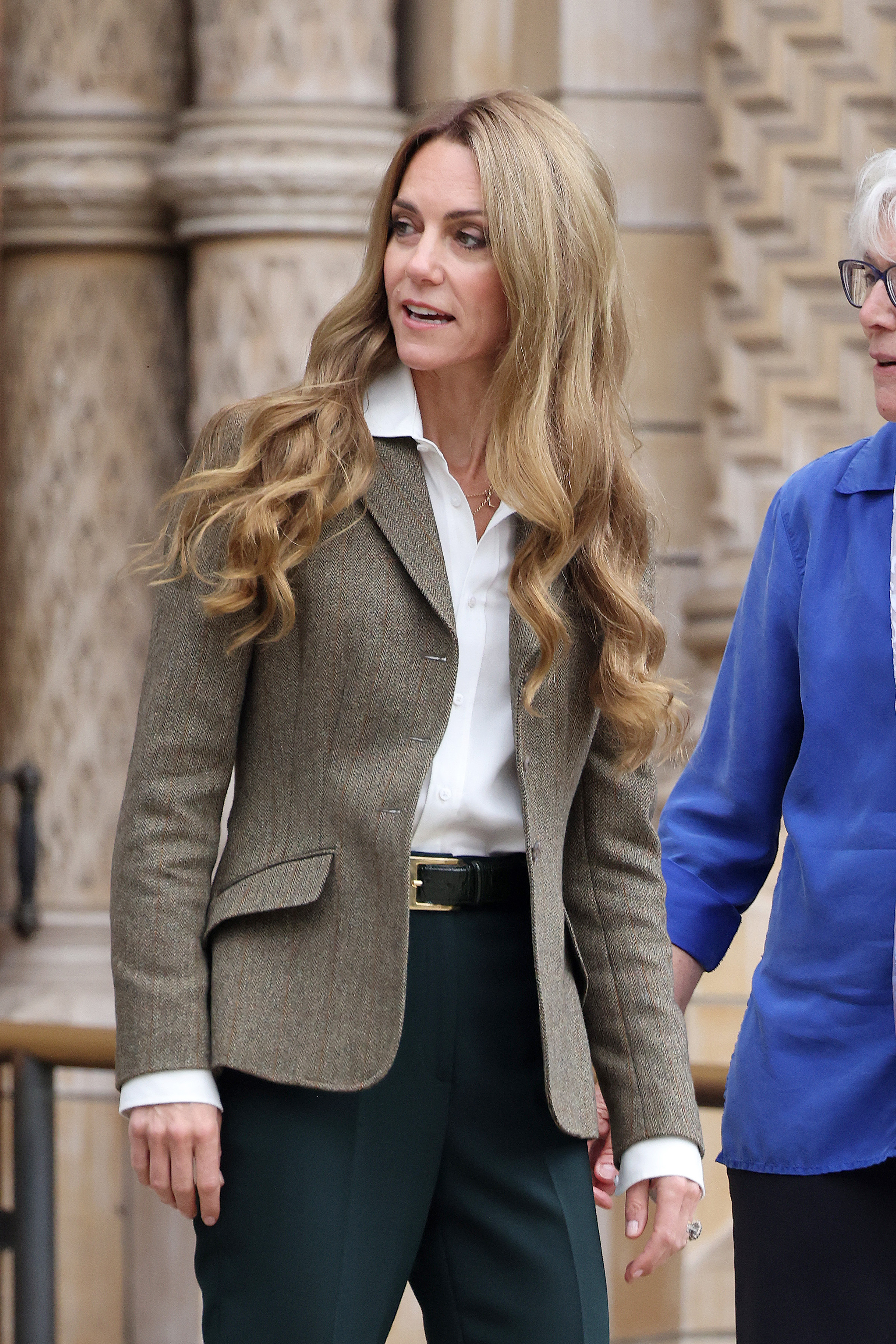 In this moment outside the museum, Princess Catherine turns slightly toward the camera, her highlighted curls catching the light. Her tailored outfit and natural makeup complement the fresh, noticeably lighter hairstyle.