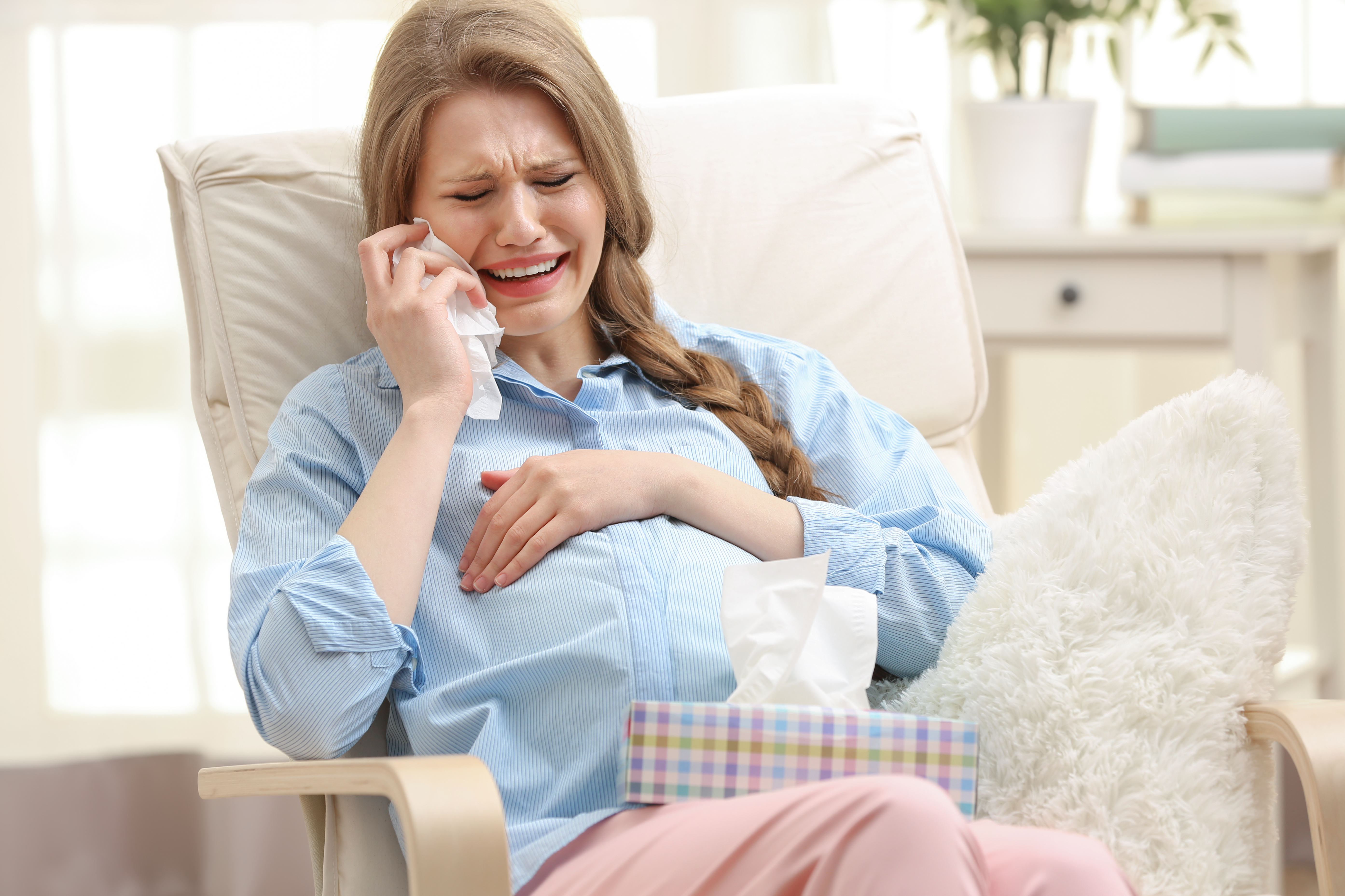 A pregnanr woman wiping her tears | Source: Shutterstock