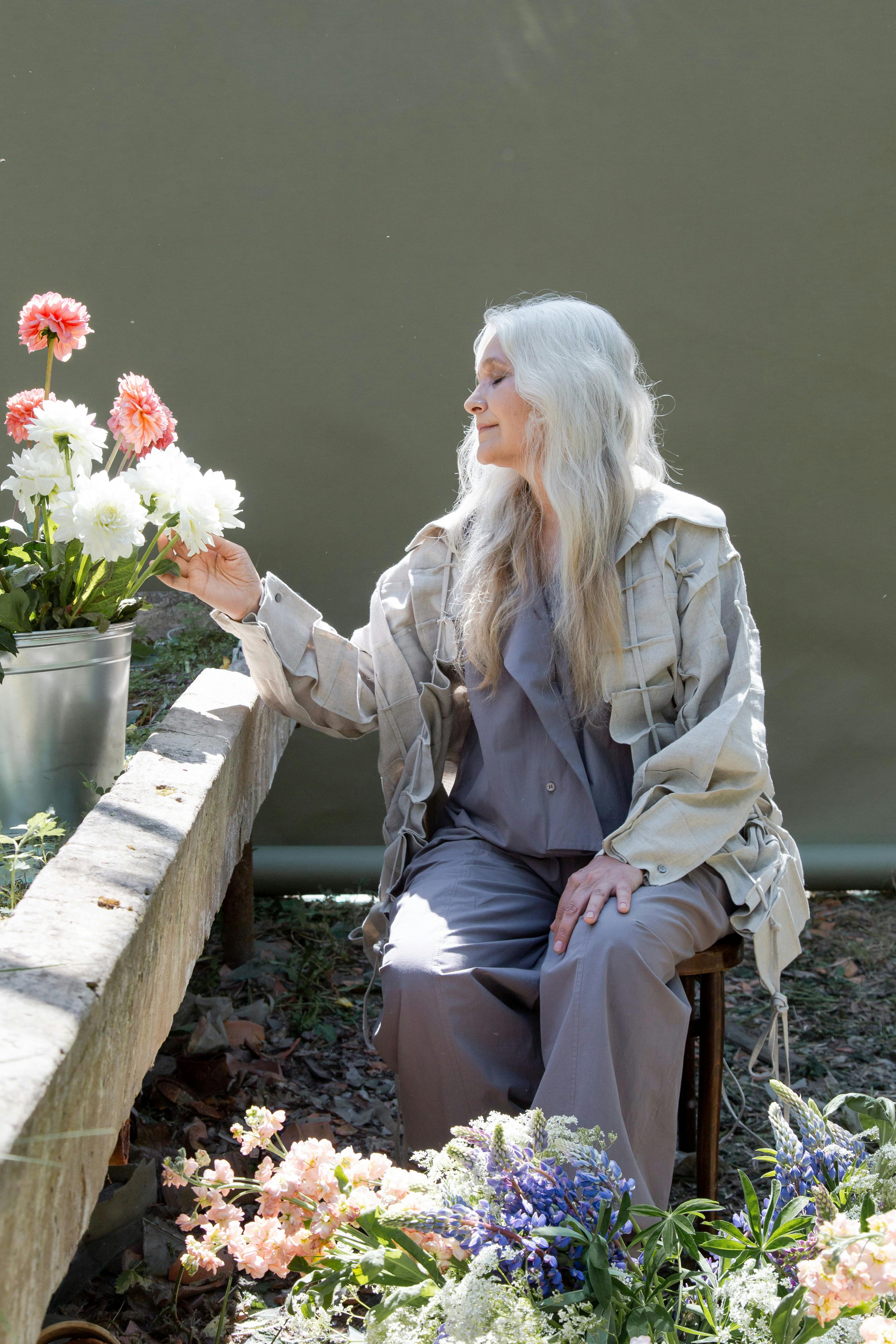 Uma mulher idosa posando com flores | Fonte: Pexels