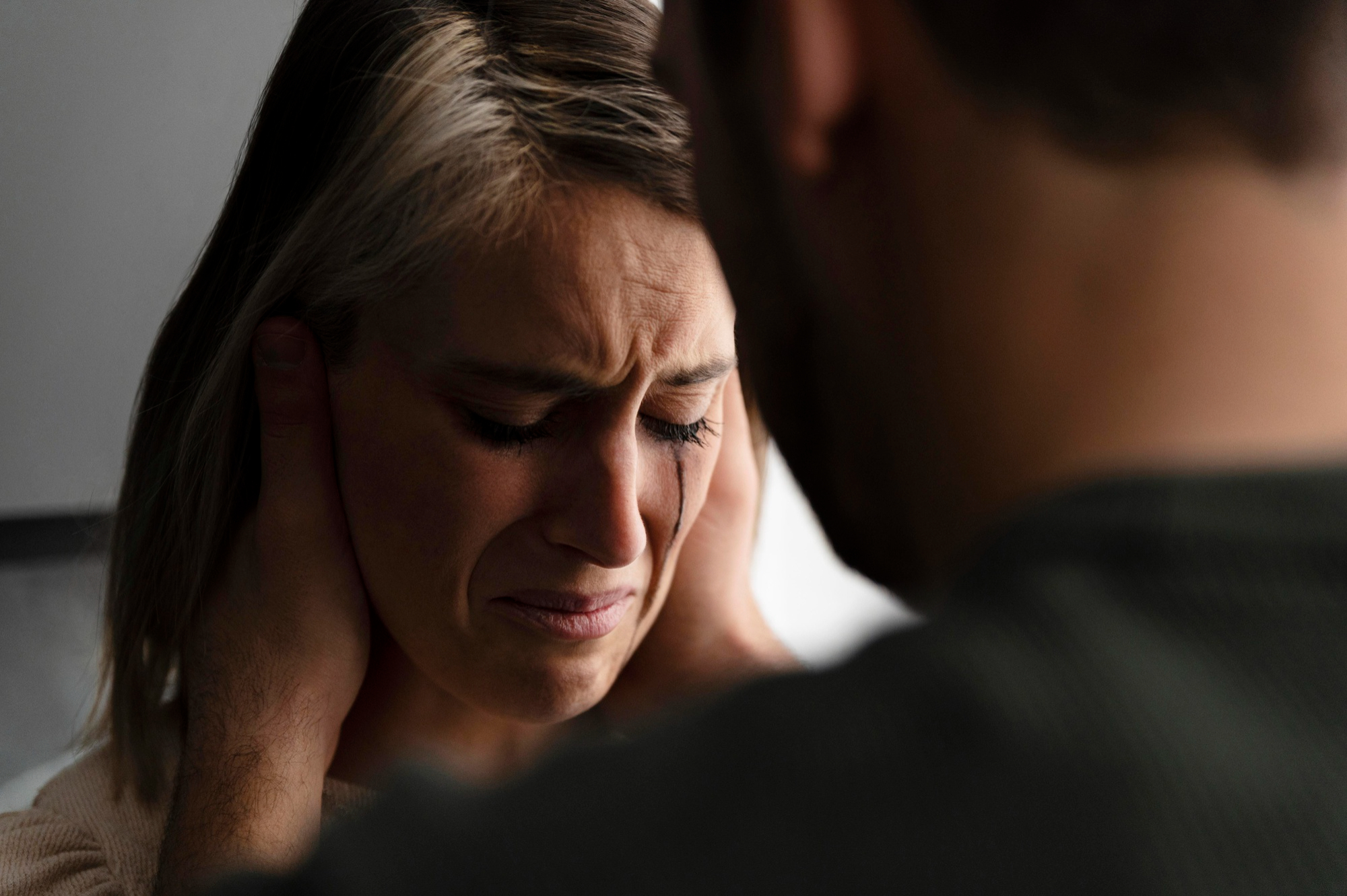 An upset woman crying while her man comforts her | Source: Freepik