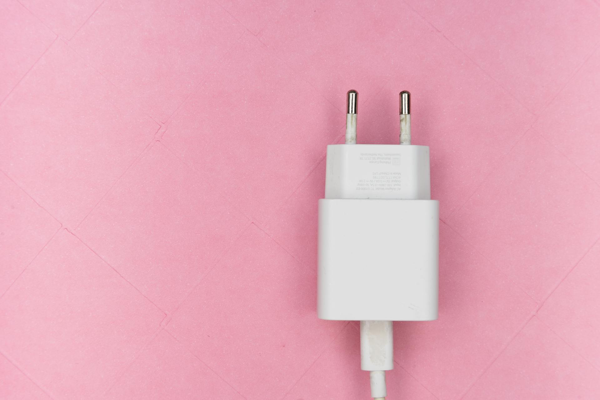 A mobile adapter on a pink surface | Source: Pexels
