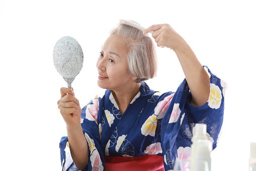 Une femme âgée se brosse les cheveux. | Photo : Getty Images