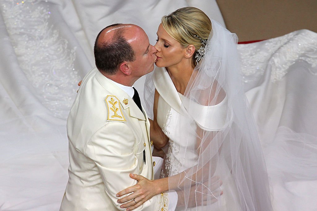 Le Prince Albert II de Monaco embrasse la Princesse Charlene de Monaco lors de leur mariage religieux dans la Cour Principale du Palais Princier le 2 juillet 2011 à Monaco. | Photo : Getty Images