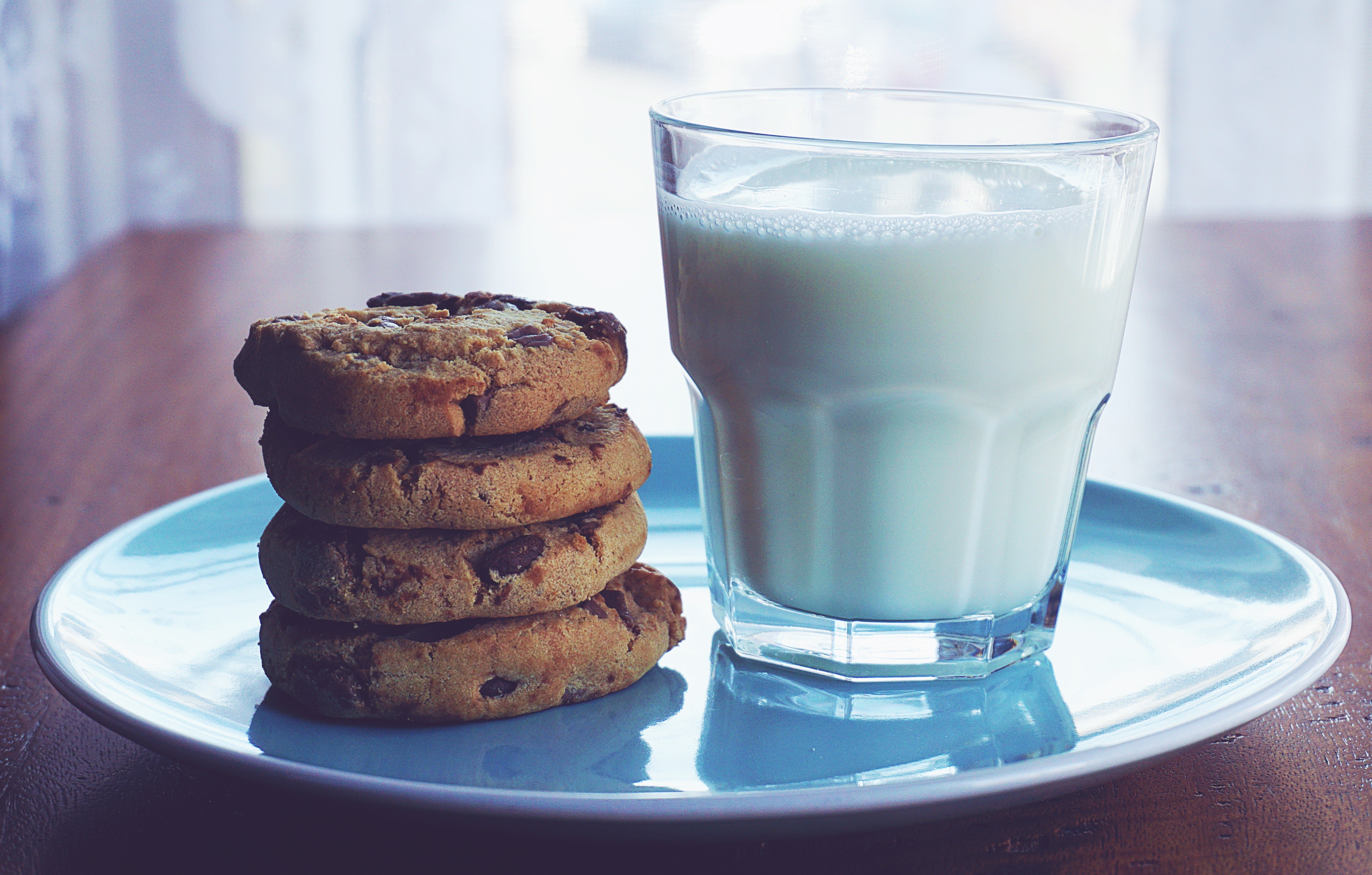 Un plato con un vaso de leche y galletas encima. | Foto: Pexels