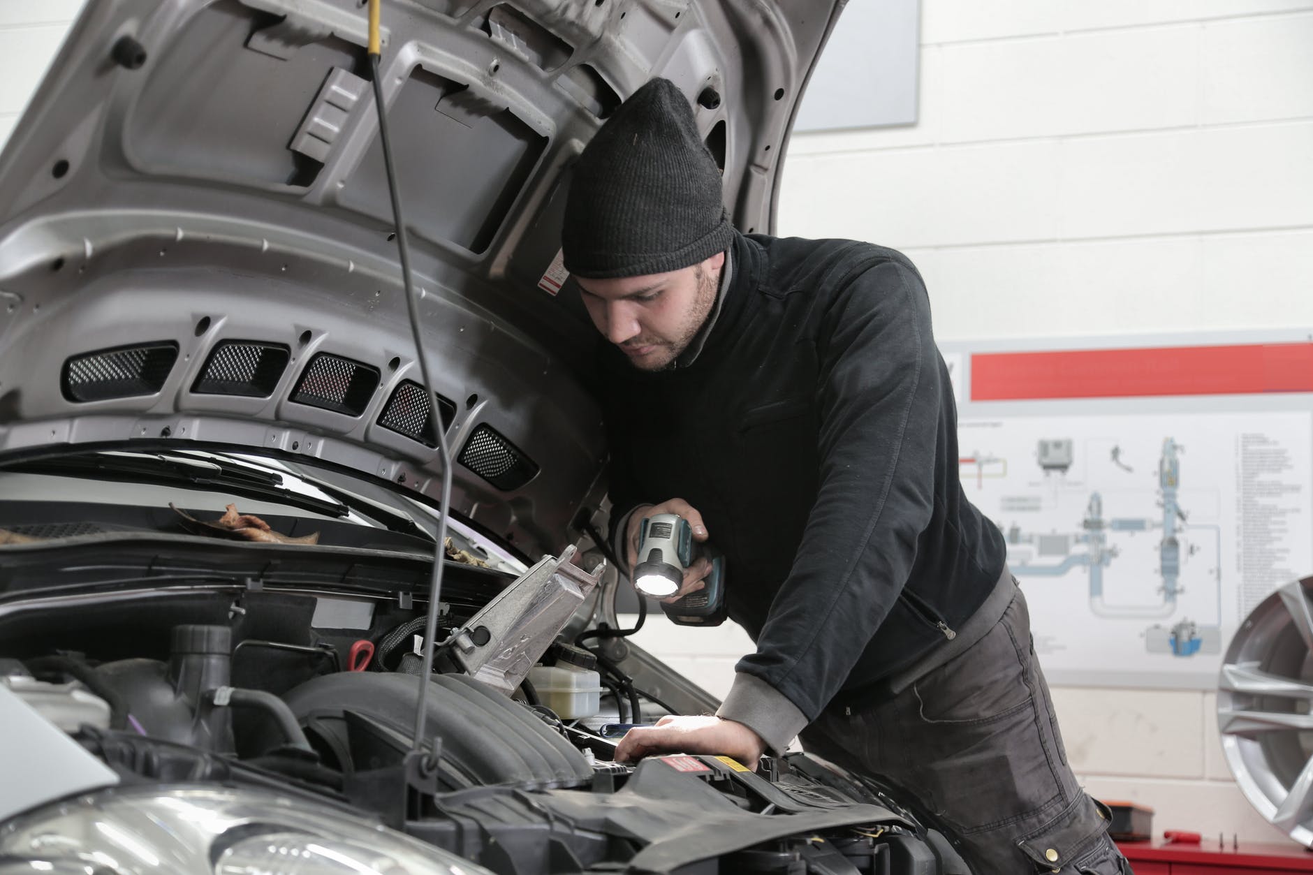 Man inspecting the car's engine. | Photo: Pexels