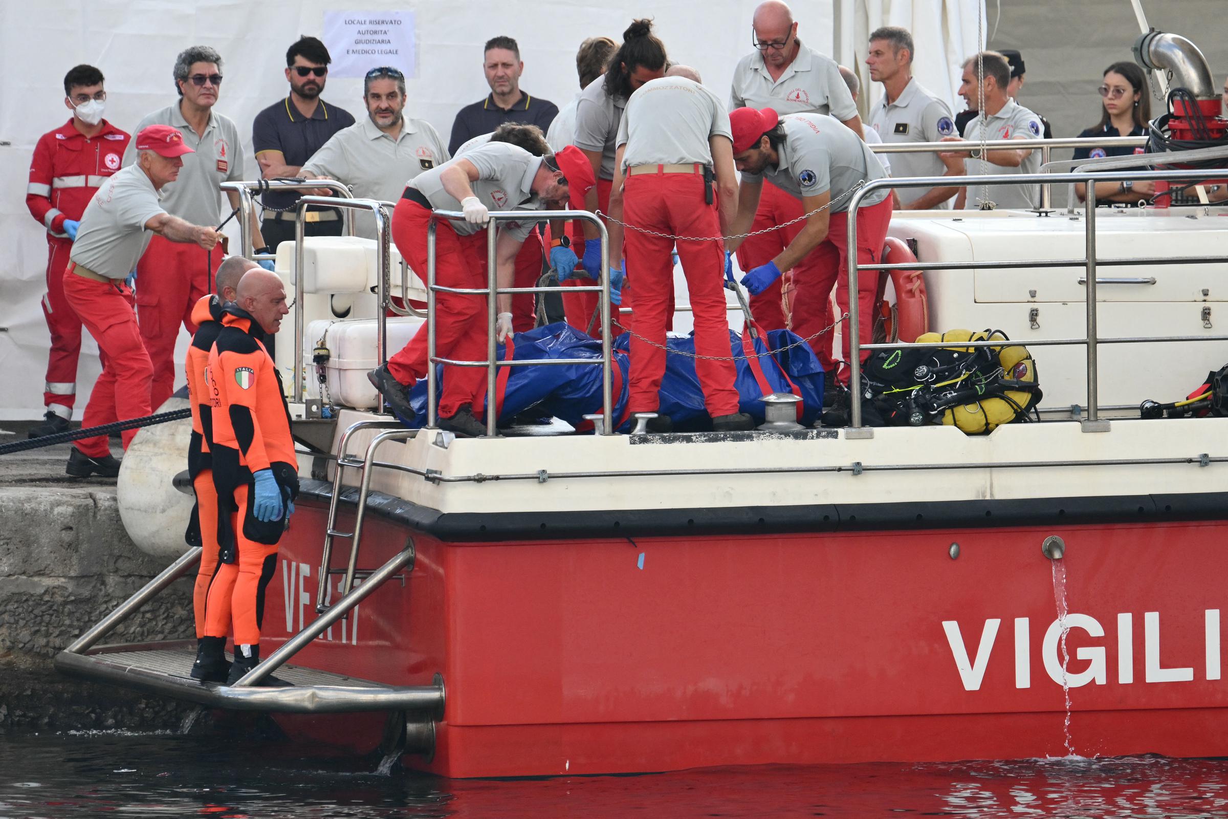 Rescuers carry a body after divers return in Porticello harbor near Palermo, on August 22, 2024, three days after the British-flagged luxury yacht Bayesian sank. | Source: Getty Images