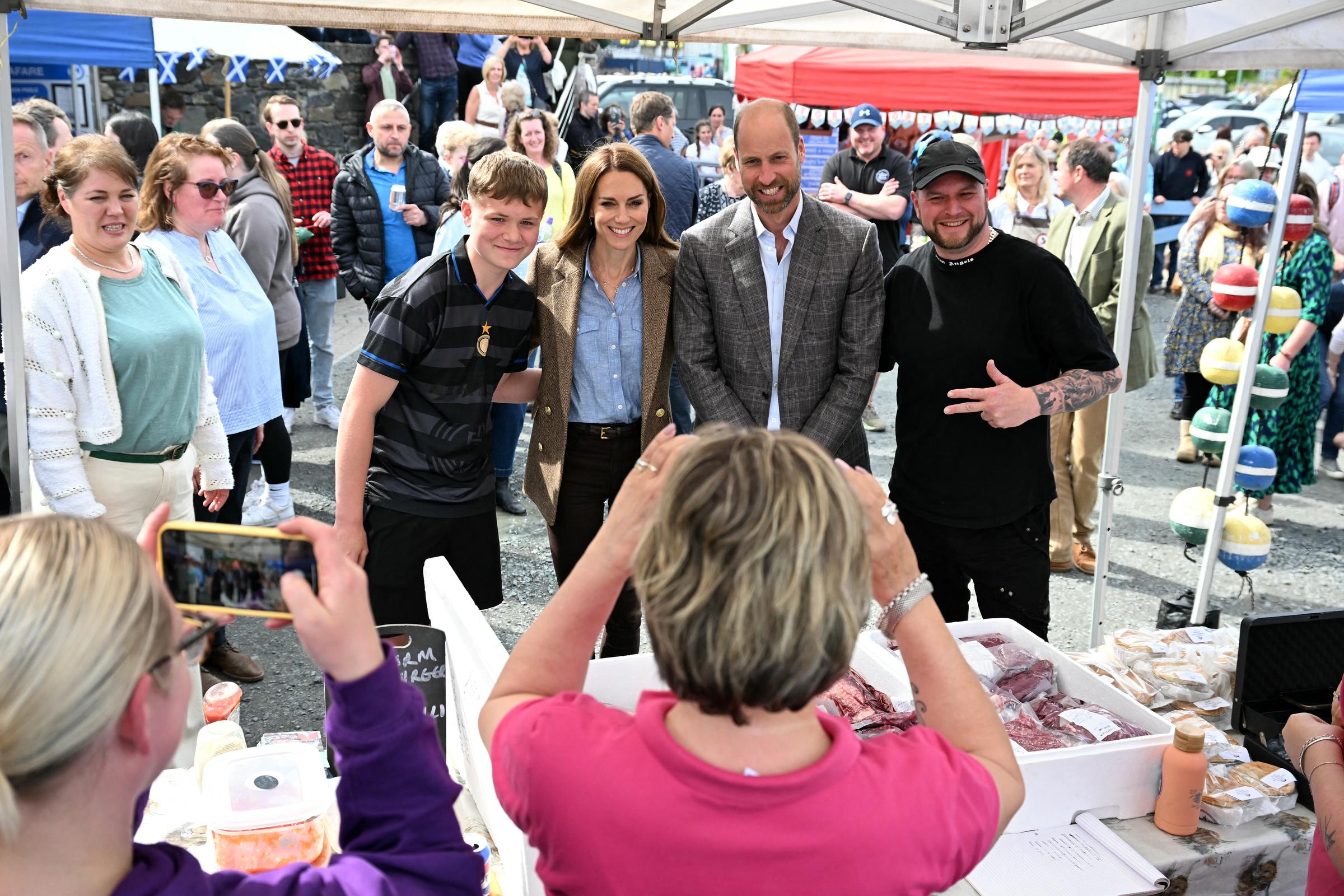 William and Catherine pose for a cheerful photo with locals at a Tobermory market stall. The pair visited the market to spotlight community entrepreneurship and small business initiatives across the island.