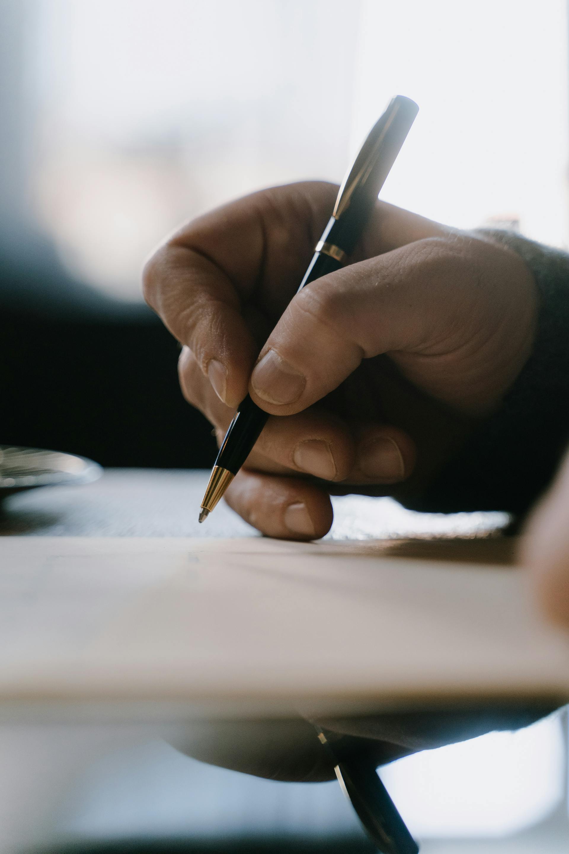 A man writing on a piece of paper | Source: Pexels