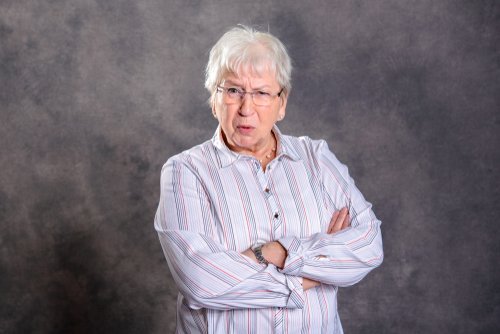 An older lady standing with her arms crossed looking angry. | Source: Shutterstock.