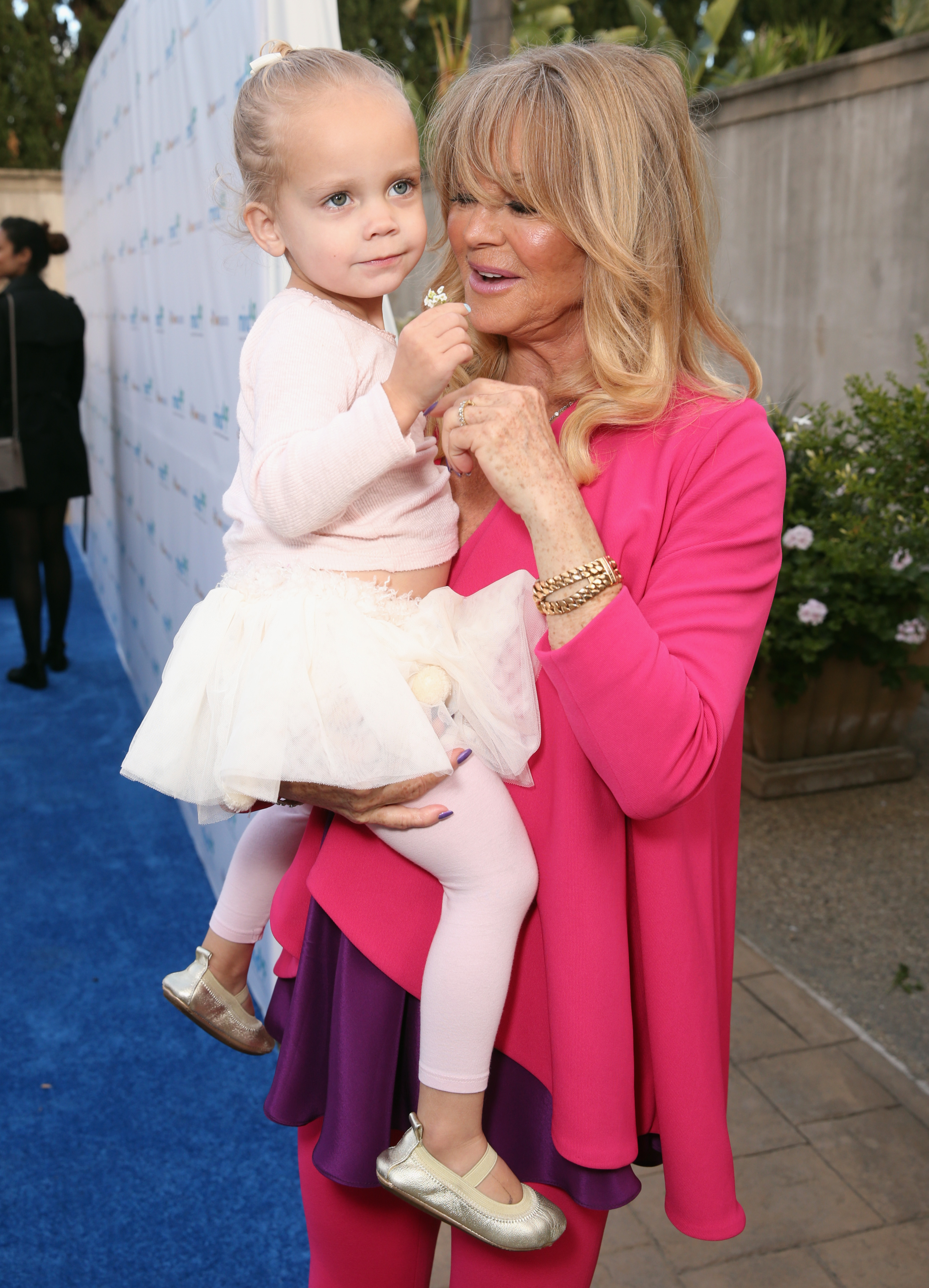 In 2016, Goldie Hawn was all smiles as she carried a giggling Rio at the annual Goldie’s Love In For Kids event. The Beverly Hills gathering marked a special appearance for the grandmother-granddaughter duo, radiating joy and family pride on the red carpet.