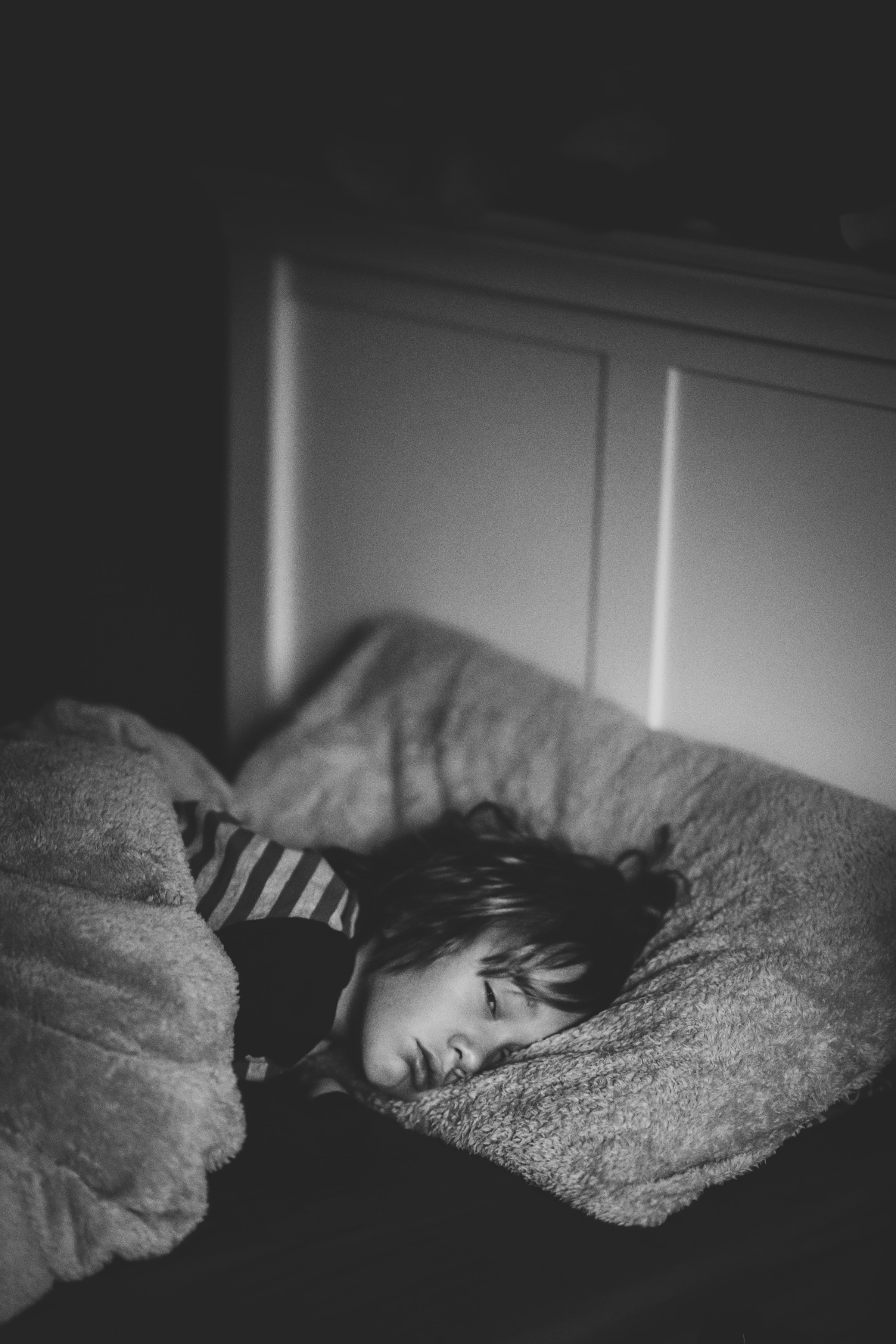 A little boy lying in bed | Source: Unsplash