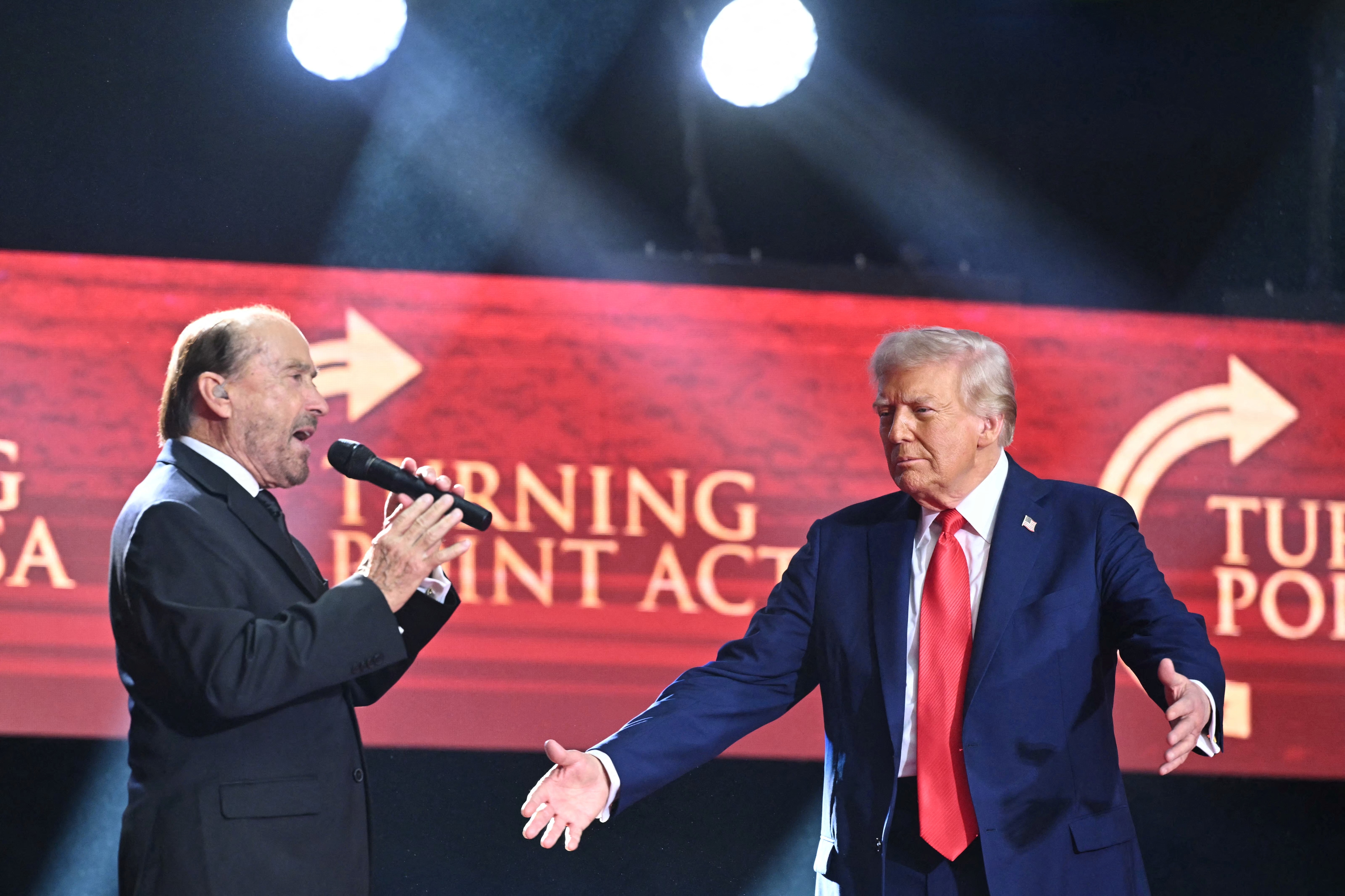 President Donald Trump is greeted by singer Lee Greenwood as he arrives to speak at the public memorial service for Charlie Kirk on September 21, 2025 | Source: Getty Images