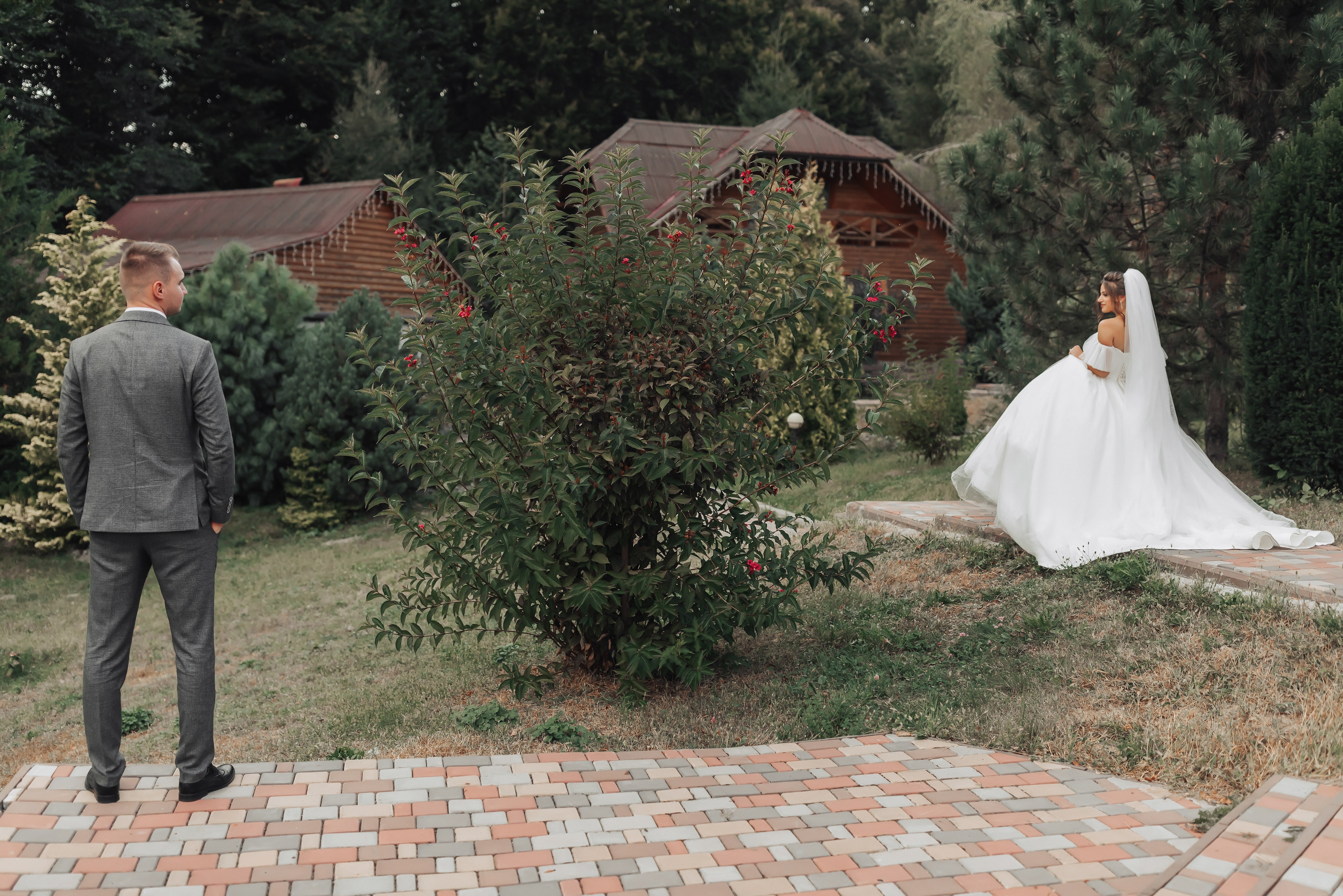 A bride and groom standing apart in a garden | Source: Shutterstock