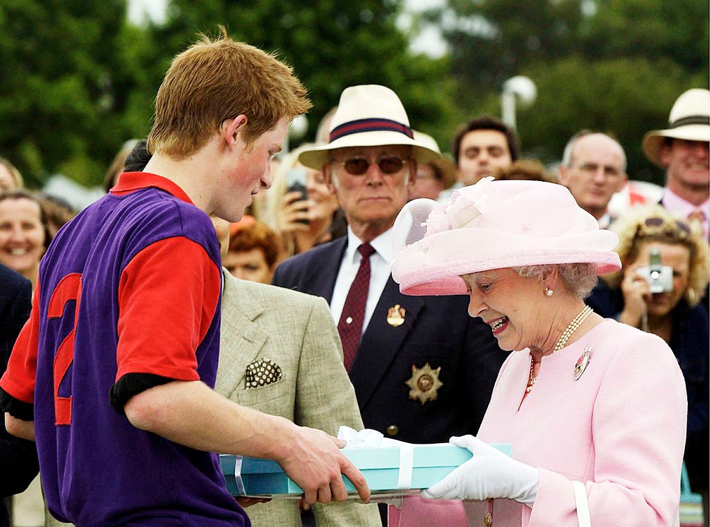 Queen Elizabeth II makes a presentation to Prince Harry after a polo match during Royal Ascot on June 18, 2003, in Windsor, England | Photo: Anwar Hussein/Getty Images