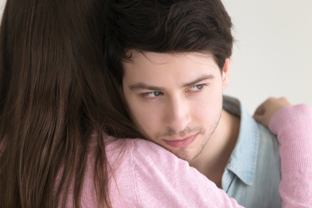 Mentiroso compulsivo abrazando a una mujer después de un engaño. Fuente: Shutterstock