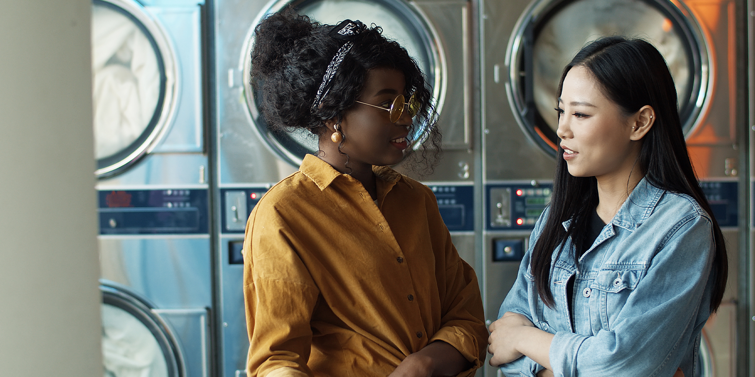 Two women in a laundromat | Source: Shutterstock