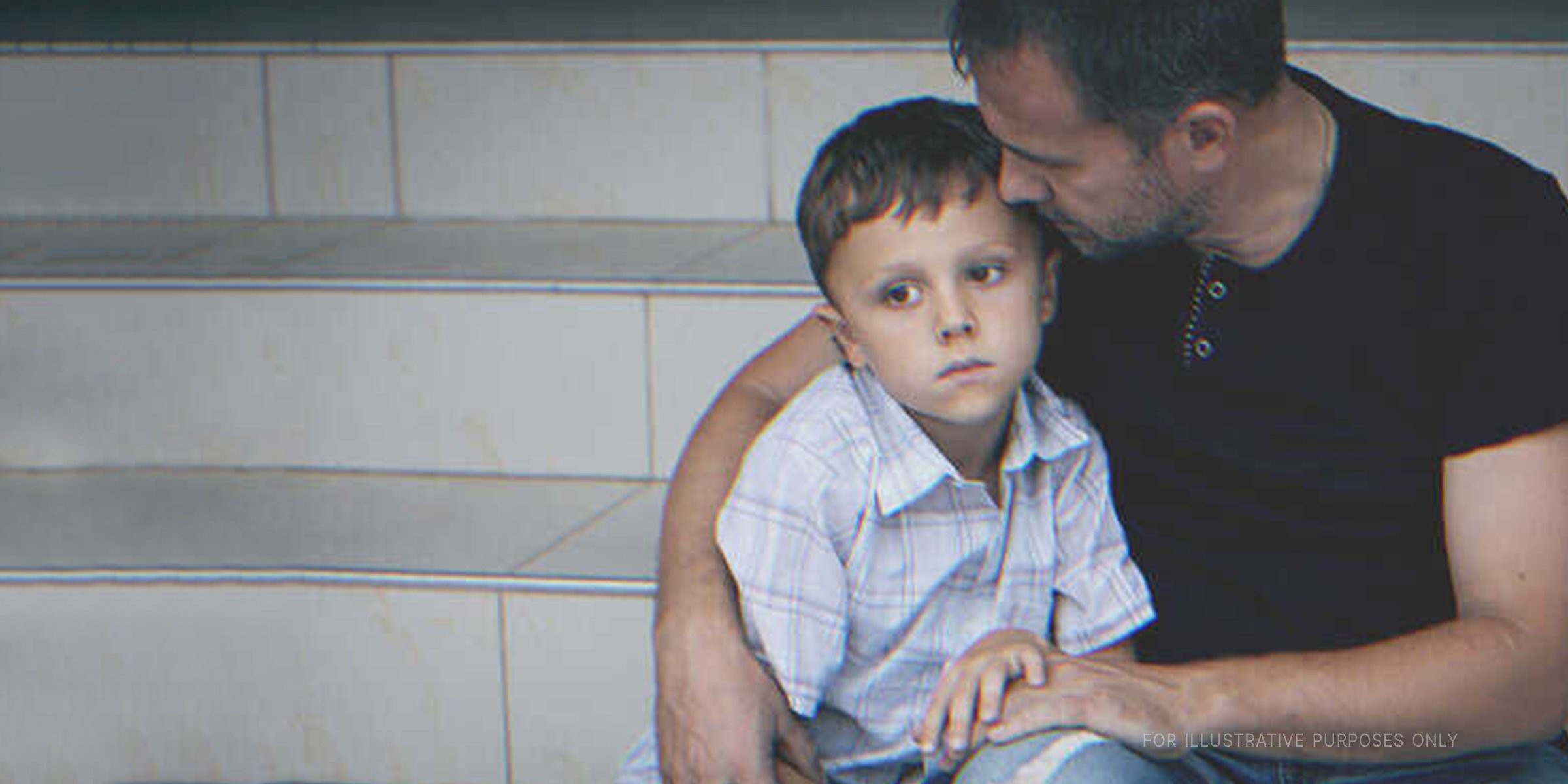 Un homme serrant son fils dans ses bras | Photo : Shutterstock
