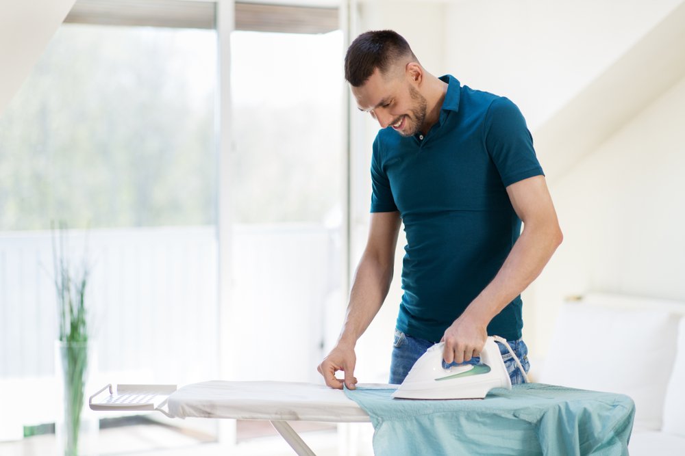 A photo of a man ironing a shirt. | Photo: Shutterstock