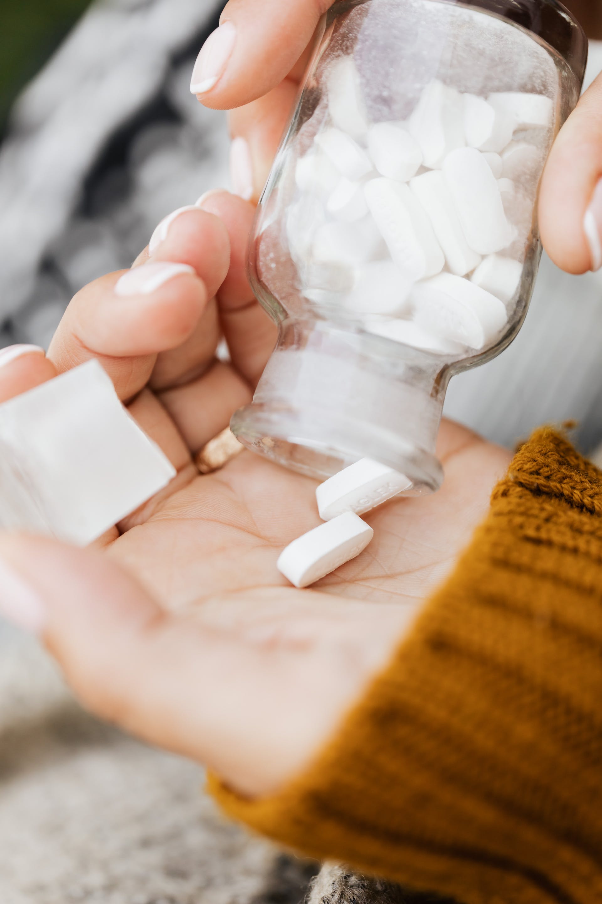 Person taking pills from a bottle | Source: Pexels