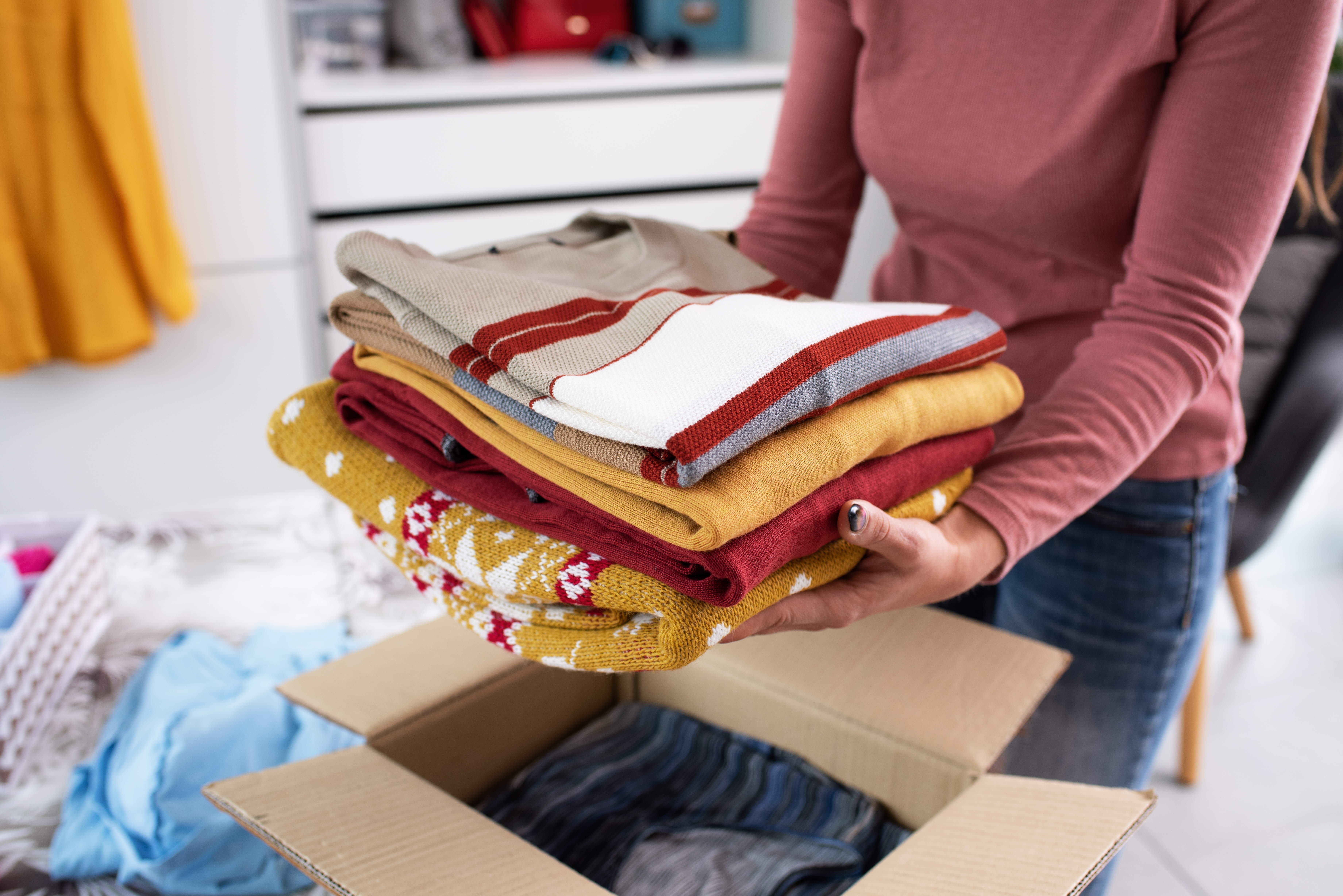 A woman packing her clothes in a box | Source: Shutterstock