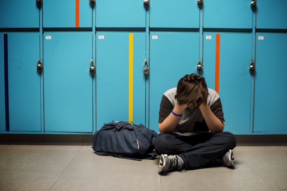 Estudiante llorando en pasillo de la escuela.|Fuente: Shutterstock Estudiante llorando en pasillo de la escuela.|Fuente: Shutterstock