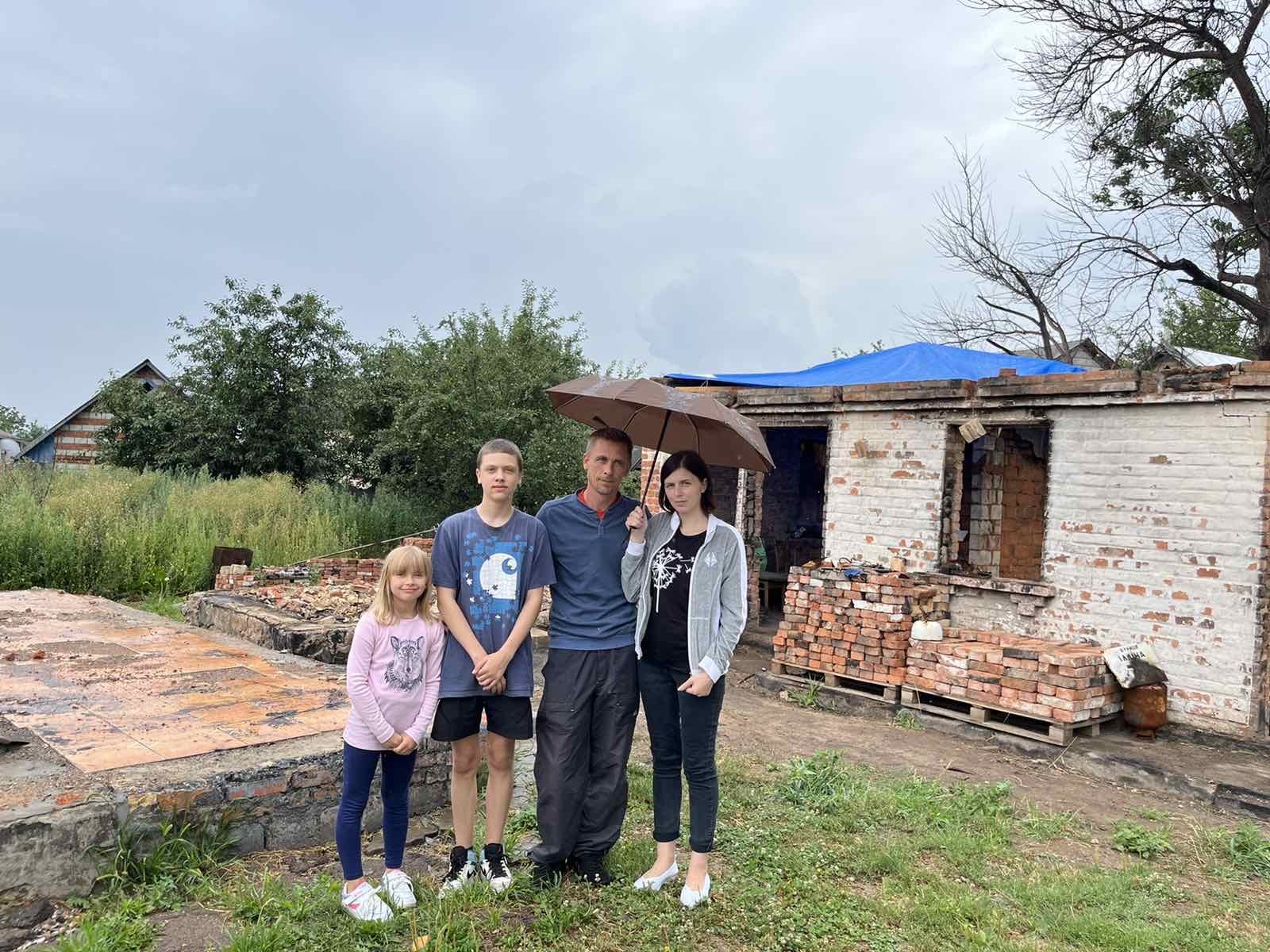 Family near the ruins of their house |  Source: NEST project