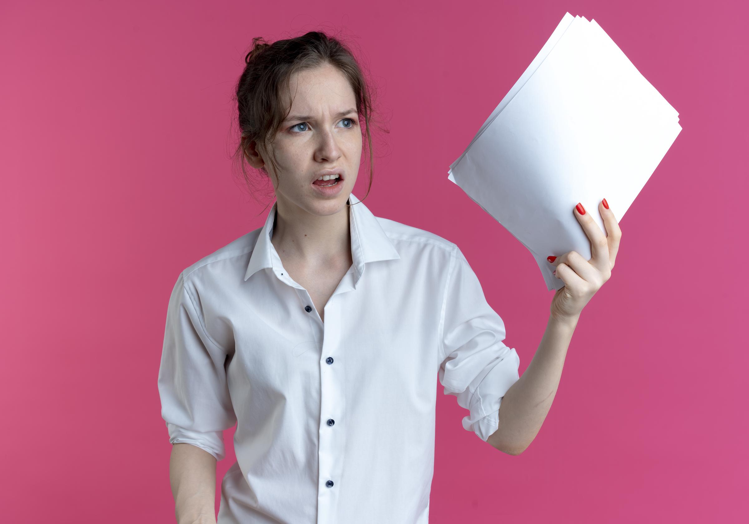 An angry woman holding up documents | Source: Freepik