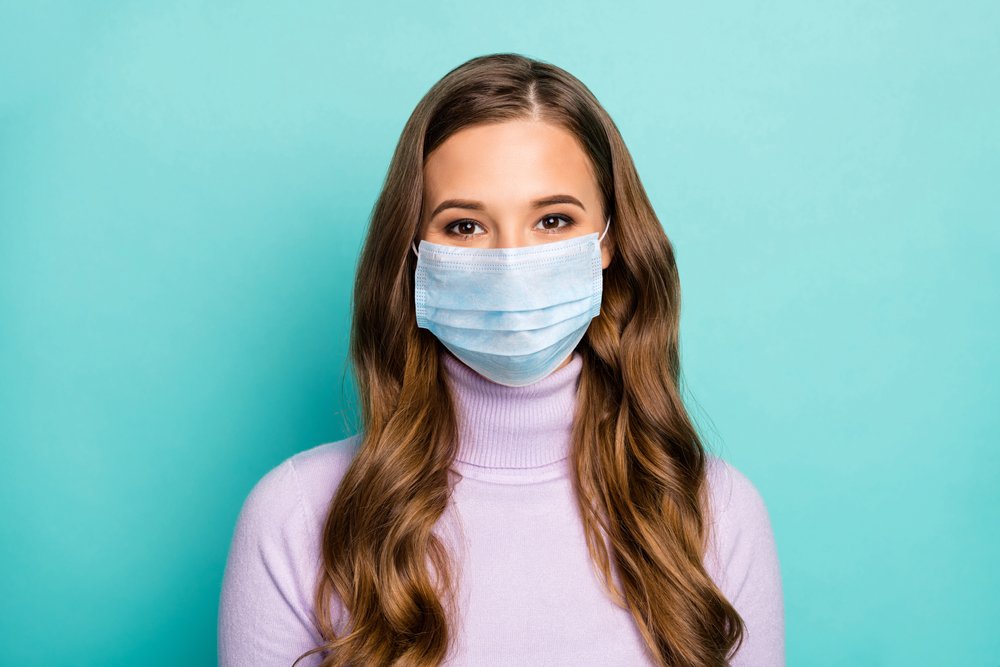Mujer con melena larga y ondulada con mascarilla en el rostro. | Foto: Shutterstock Mujer con melena larga y ondulada con mascarilla en el rostro. | Foto: Shutterstock
