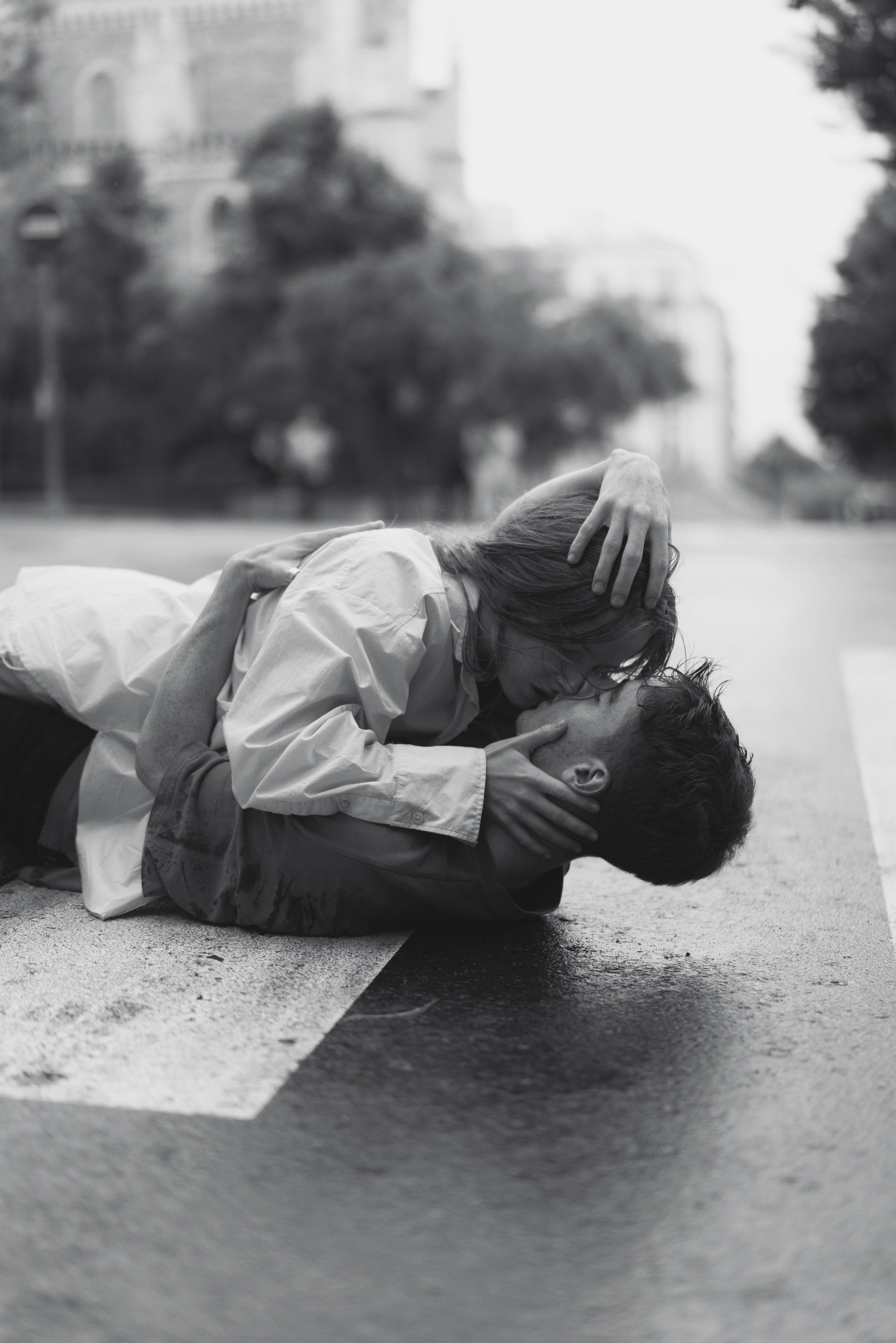 A couple kissing while lying down on the road. | Source: Pexels