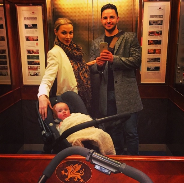 Shared on 4 April 2015, Caroline and Adam Thomas pose for a stylish mirror selfie inside a lift, with their baby nestled comfortably in a pram — a polished yet personal snapshot that blends early parenthood with the couple's effortlessly coordinated flair. | Source: Instagram/carolinethomas23