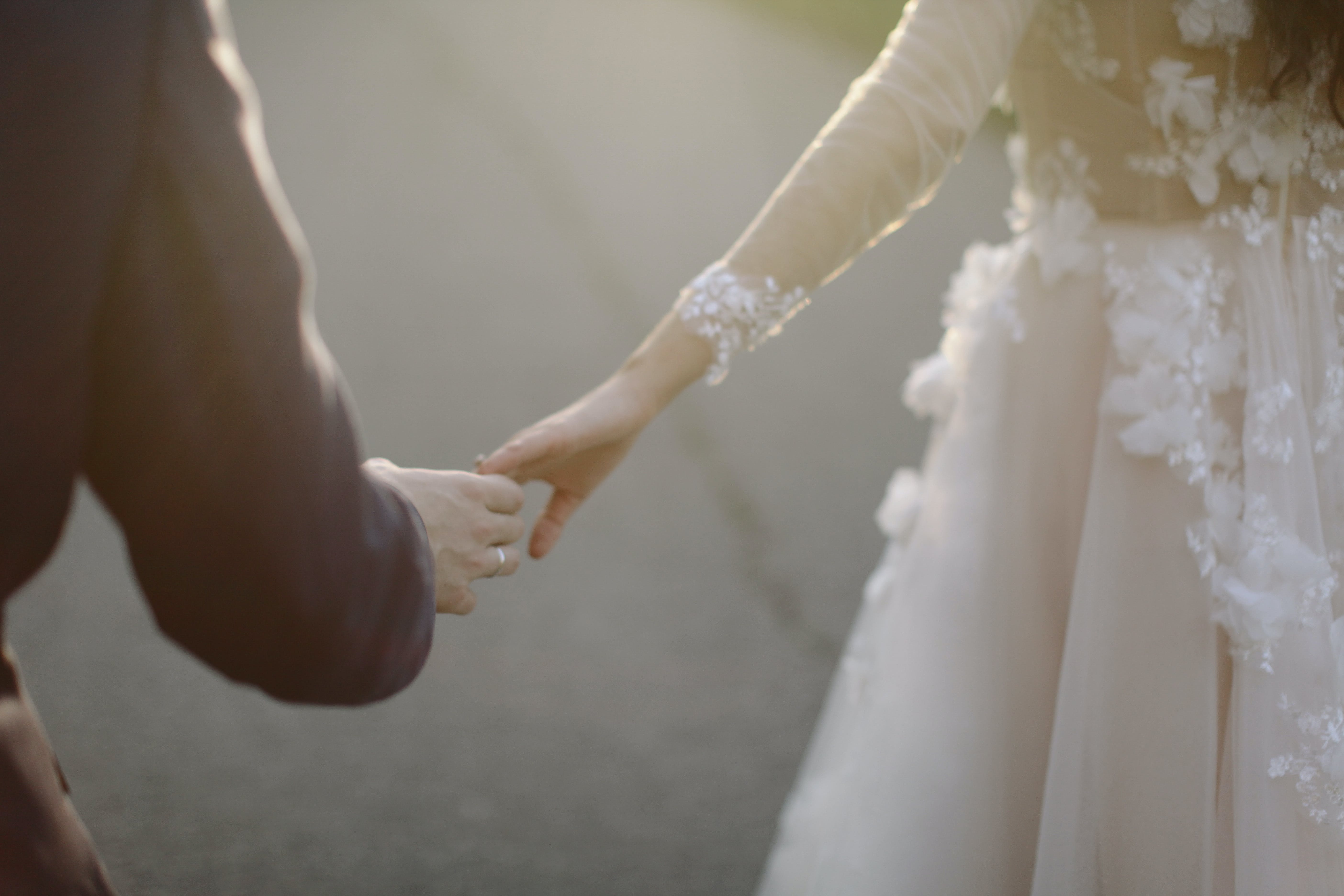 A bride and groom touching hands | Source: Pexels