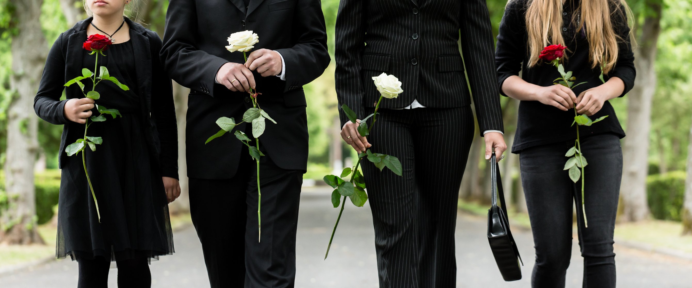 Die Familie hält Rosen, während sie während einer Beerdigung hinter einem Sarg spazieren geht. I Quelle: Getty Images