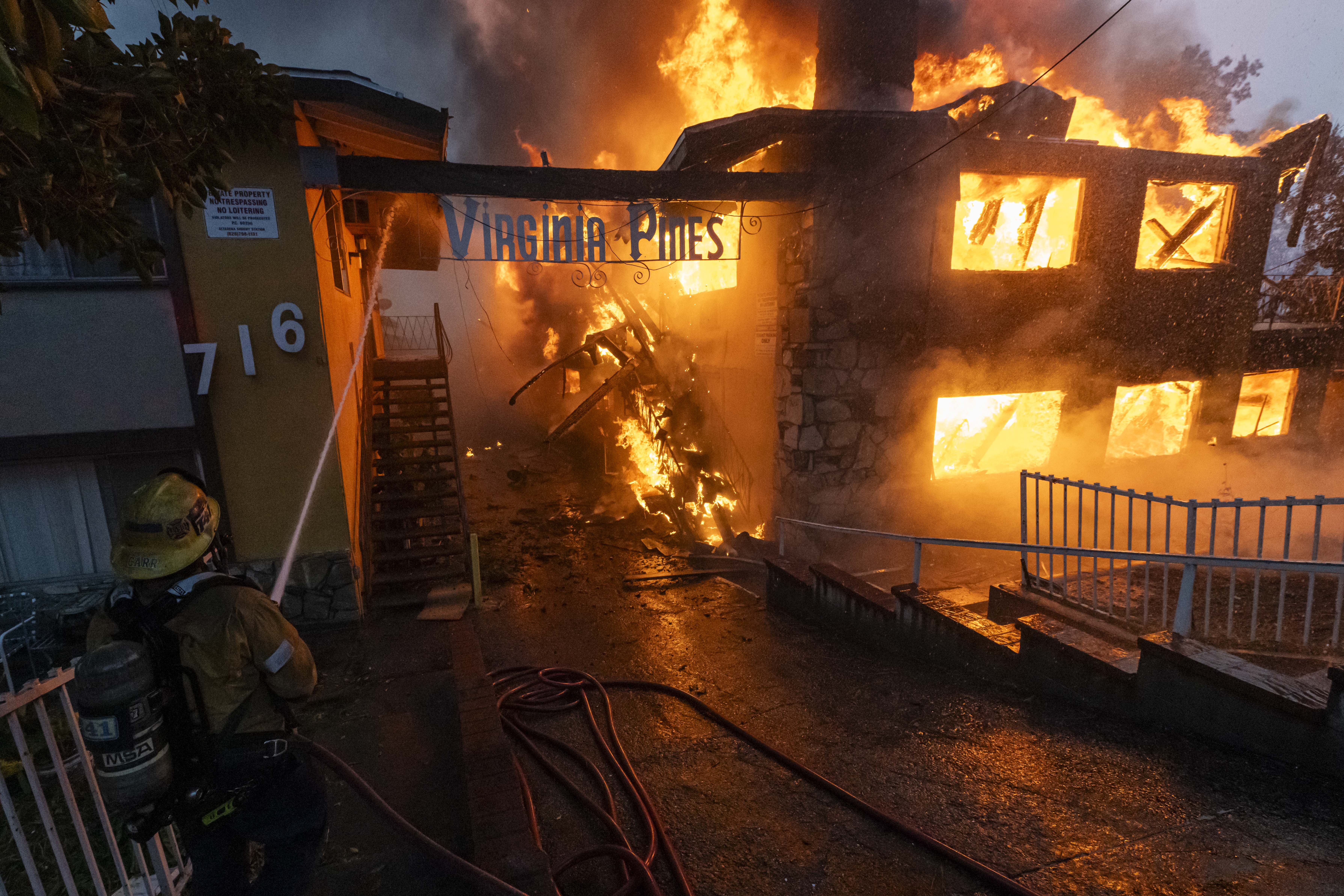 An LAFD Firefighter hosing a burning apartment complex from the Eaton Fire in Altadena, California, on January 8, 2025 | Source: Getty Images