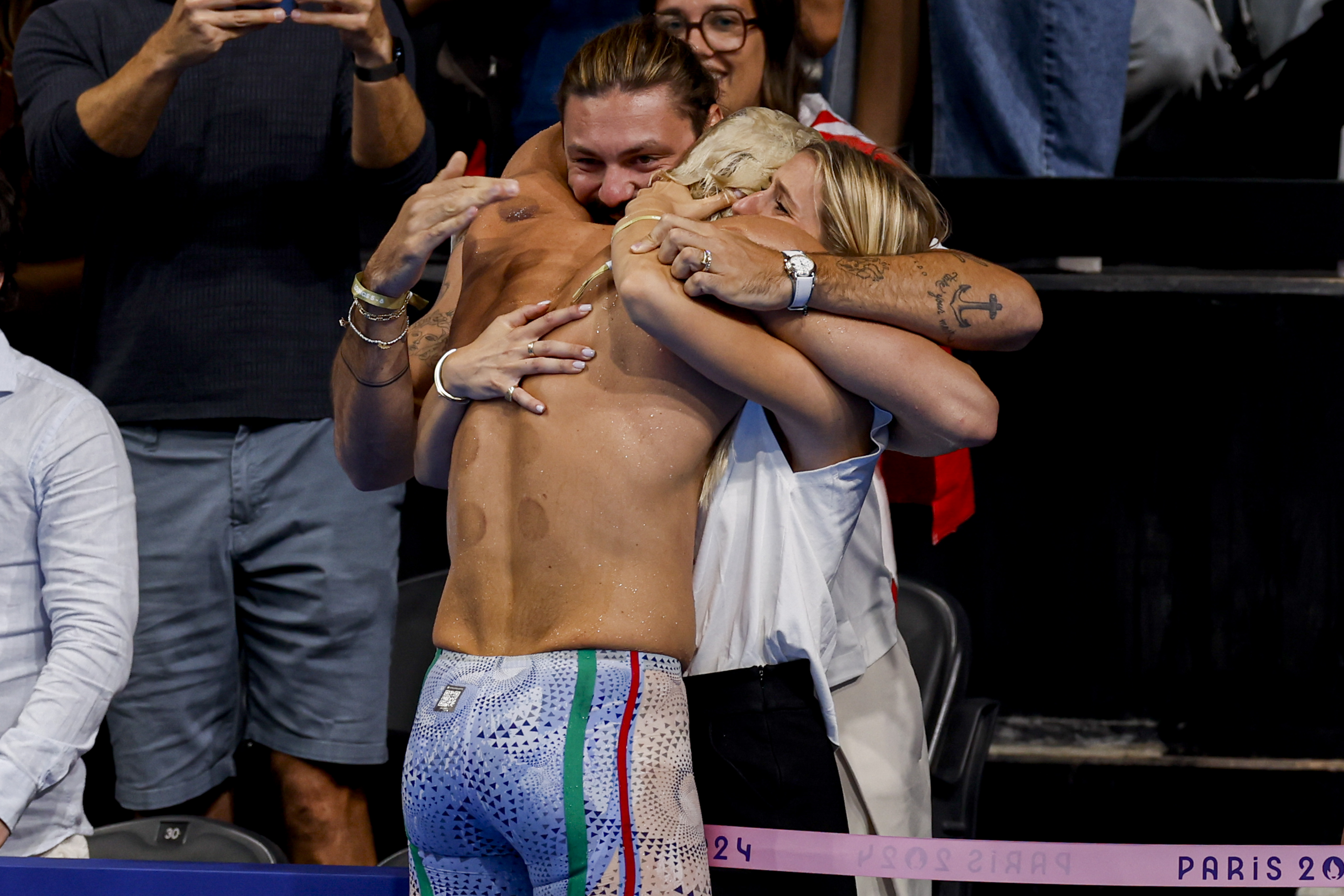 Nicolo Martinenghi of Italy celebrates with hugs after winning the Mens 100m Breaststroke Final at the Paris 2024 Olympic Games on July 28, 2024 | Source: Getty Images