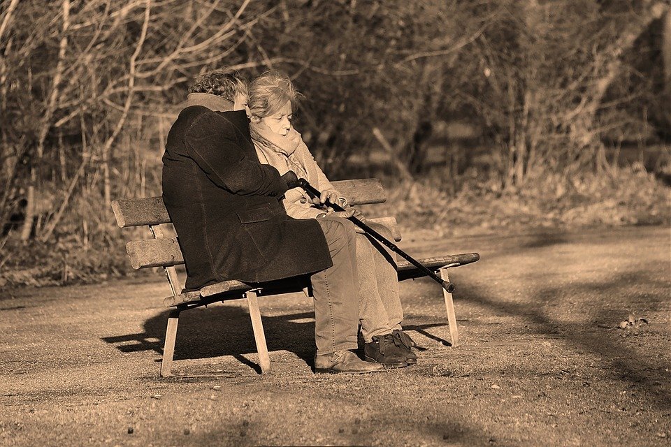 Un couple âgé discutant sur un banc. | Photo : Pixabay