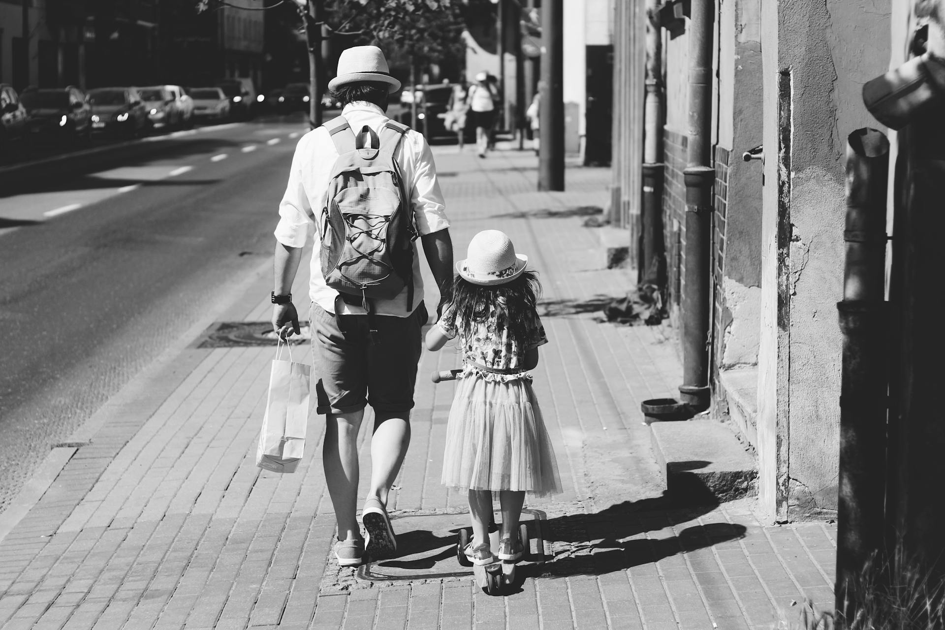 Father and daughter walking on street | Source: Pexels