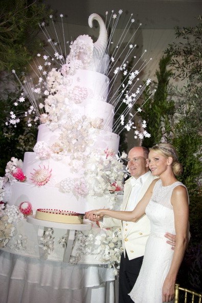 In diesem Bild, das vom Palais Princier zur Verfügung gestellt wurde, schneiden Fürstin Charlene von Monaco und Fürst Albert II. von Monaco die Torte während der religiösen Zeremonie der königlichen Hochzeit, im Haupthof des Fürstenpalastes am 2. Juli 2011 in Monaco | Quelle: Getty Images