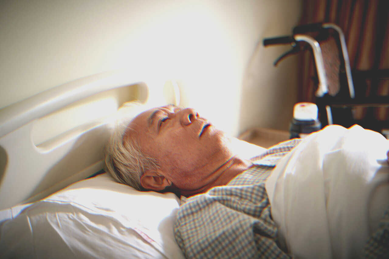 Older man in hospital bed | Source: Shutterstock
