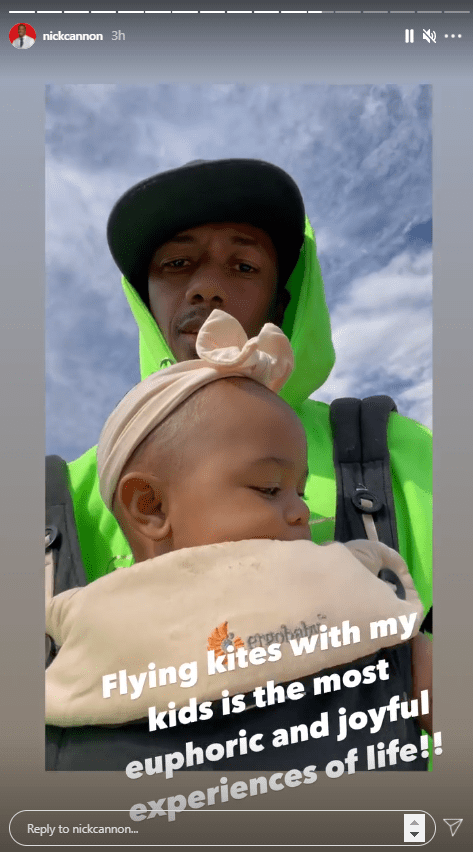 Nick Cannon flying kites with his daughter strapped to his chest. | Photo: Instagram/@nickcannon