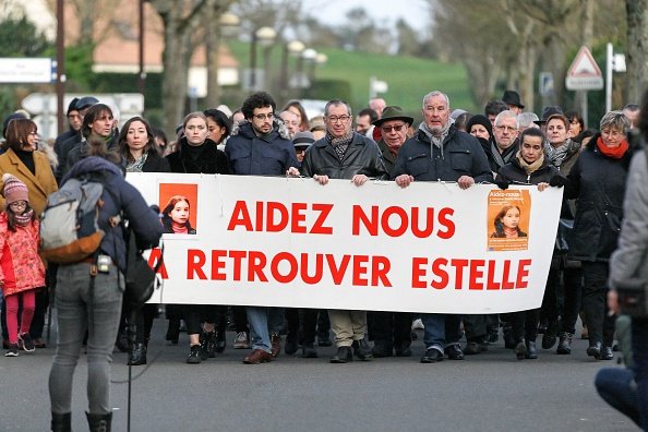La famille d'Estelle Mouzin, dont le père, Eric Mouzin (C), tient une banderole sur laquelle on peut lire : "Aidez-nous à retrouver Estelle lors d'une marche silencieuse à Guermantes, près de Paris.|Photo : Getty Images.