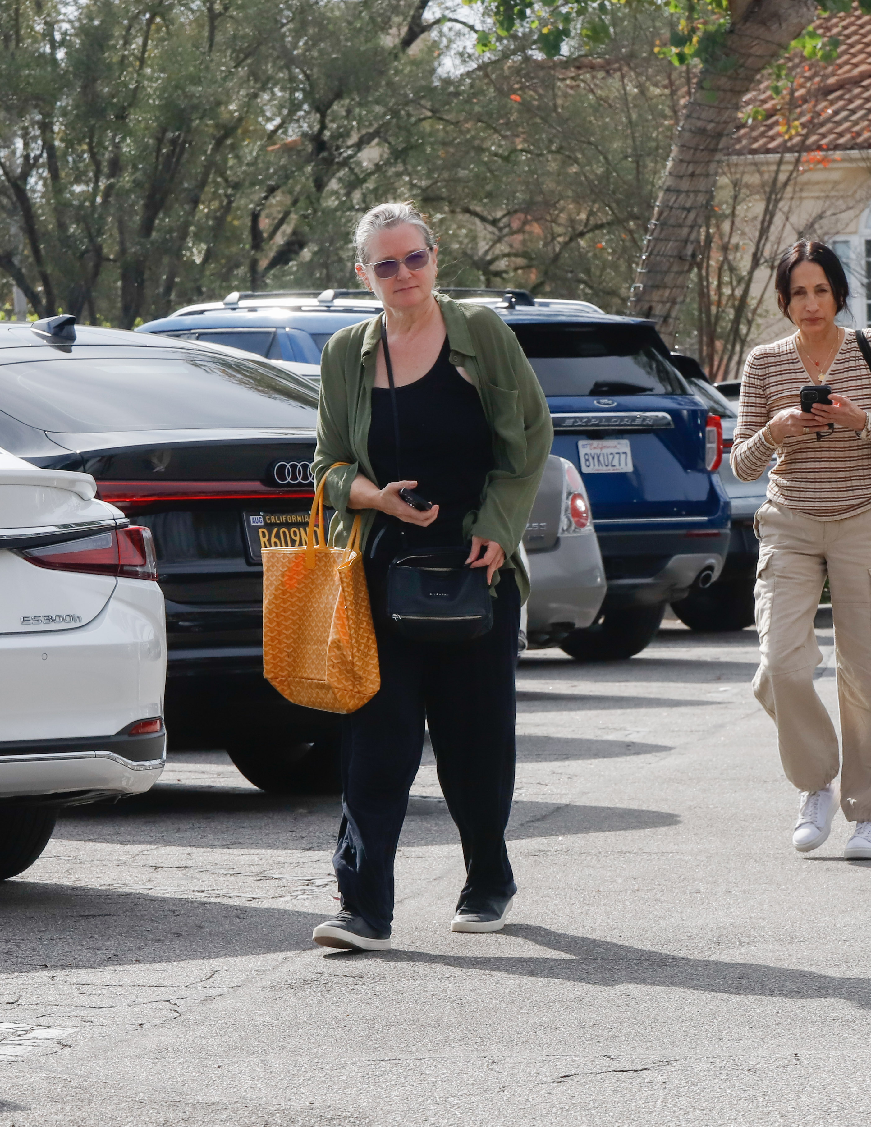 Bridget Fonda was spotted out and about in Los Angeles on November 11, 2025, dressed in a loose-fitting green overshirt layered over a black tank and wide-leg trousers. She kept her look casual and functional, accessorised with two crossbody bags and oversized sunglasses.