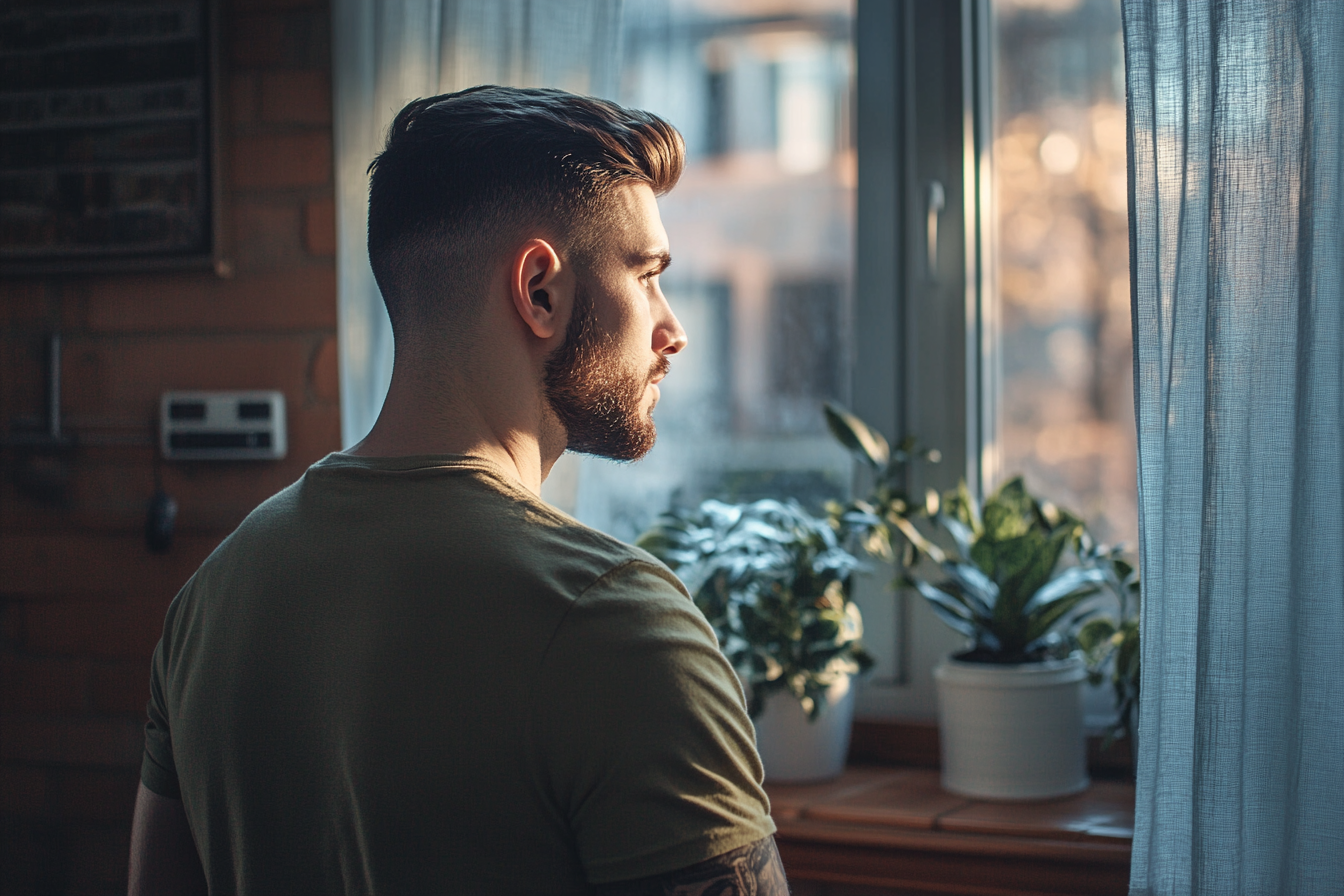 A man looking outside the window | Source: Midjourney