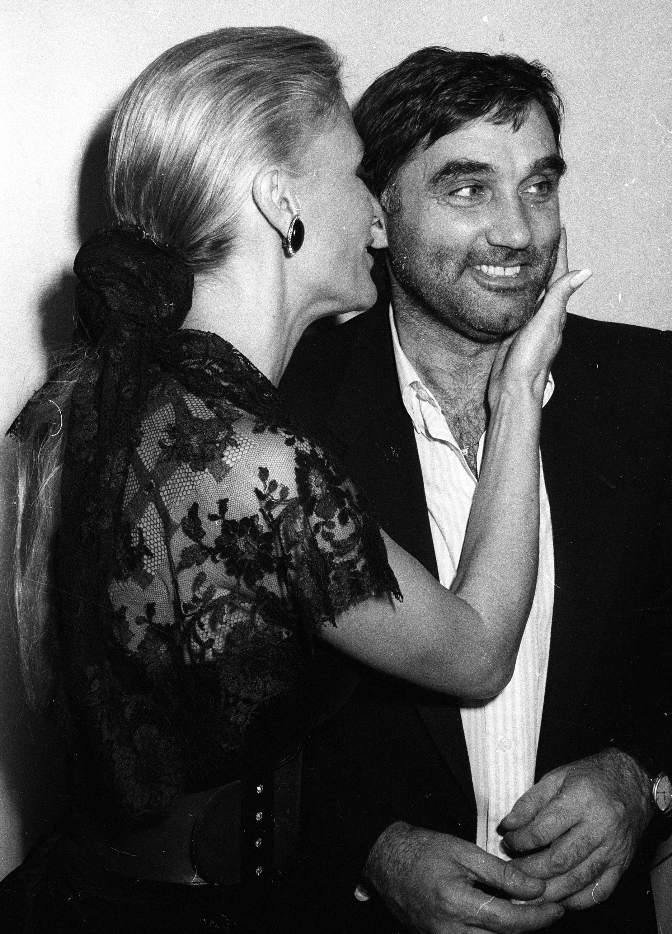 Angie Best is pictured alongside football legend George Best, leaning in close as she smiles, her hand resting gently against his face in an affectionate moment captured during their earlier years.