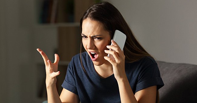 A woman looks angry while talking on the phone. | Photo: Shutterstock