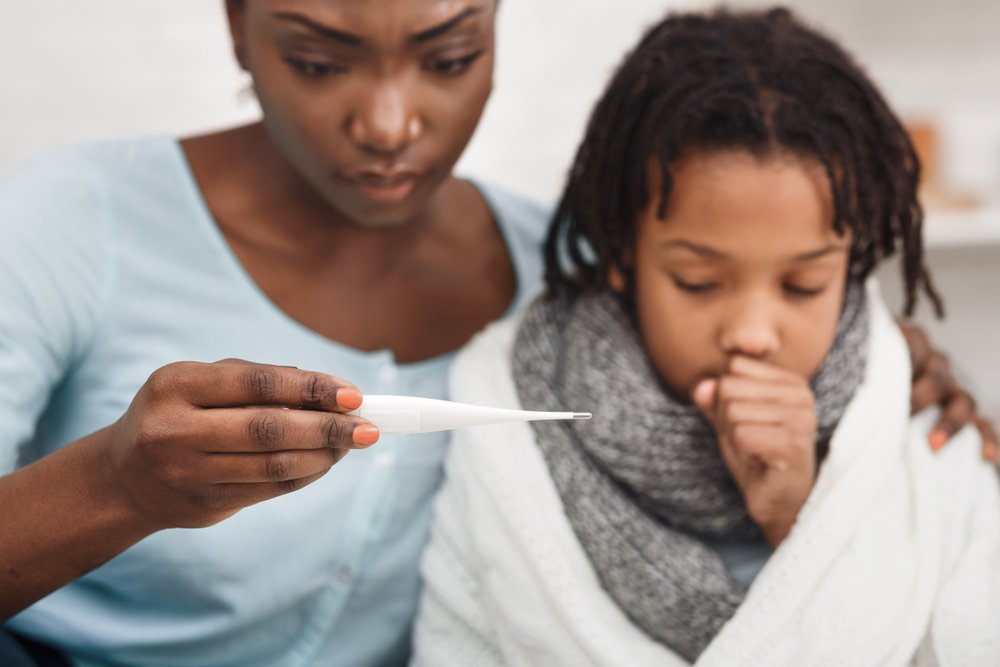 Mujer tomando la temperatura de su hija. | Foto: Shutterstock
