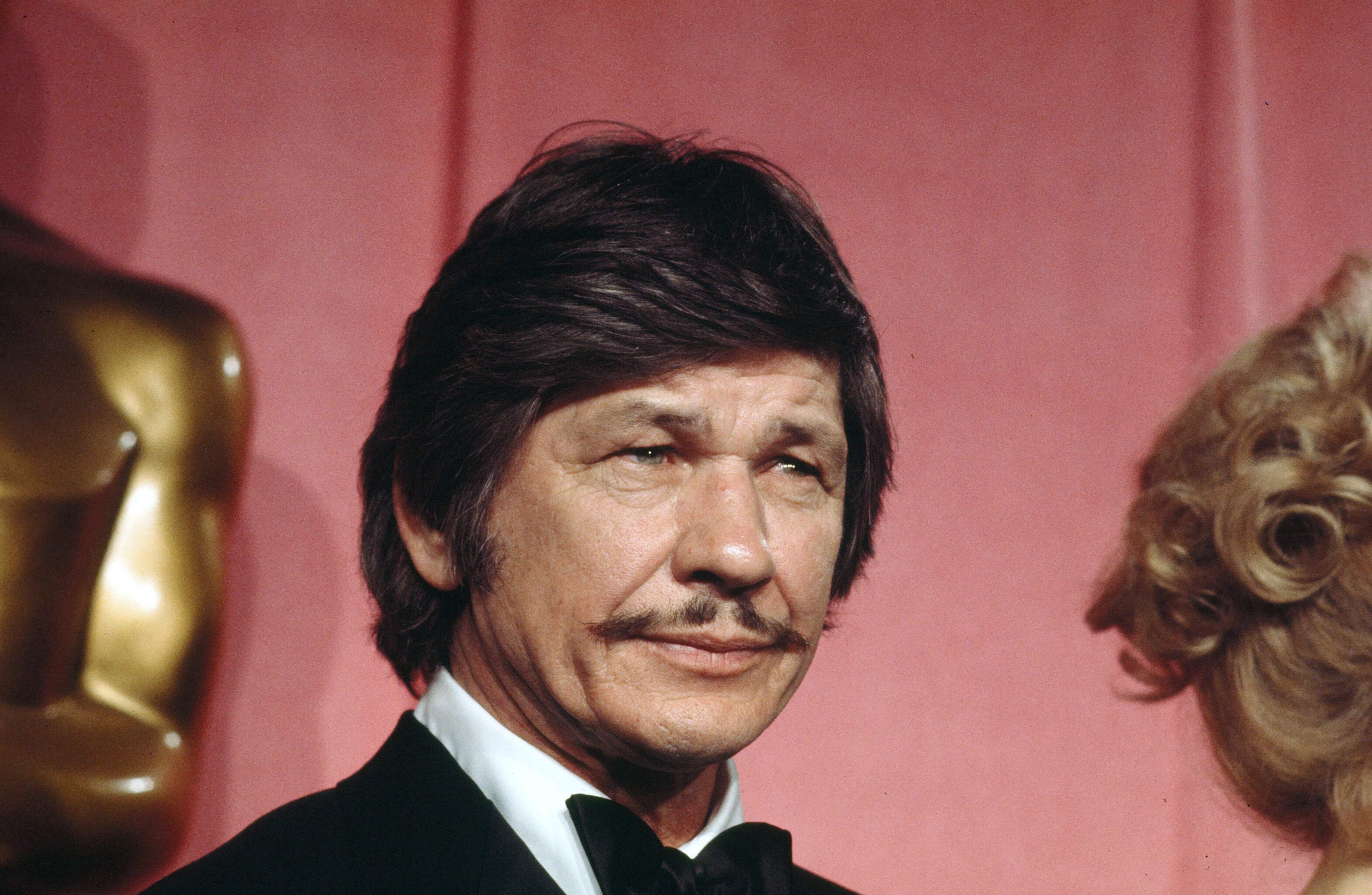 Actor Charles Bronson poses backstage after presenting "Best Supporting Actress" award during the 46th Academy Awards at Dorothy Chandler Pavilion in Los Angeles, California. | Source: Getty Images